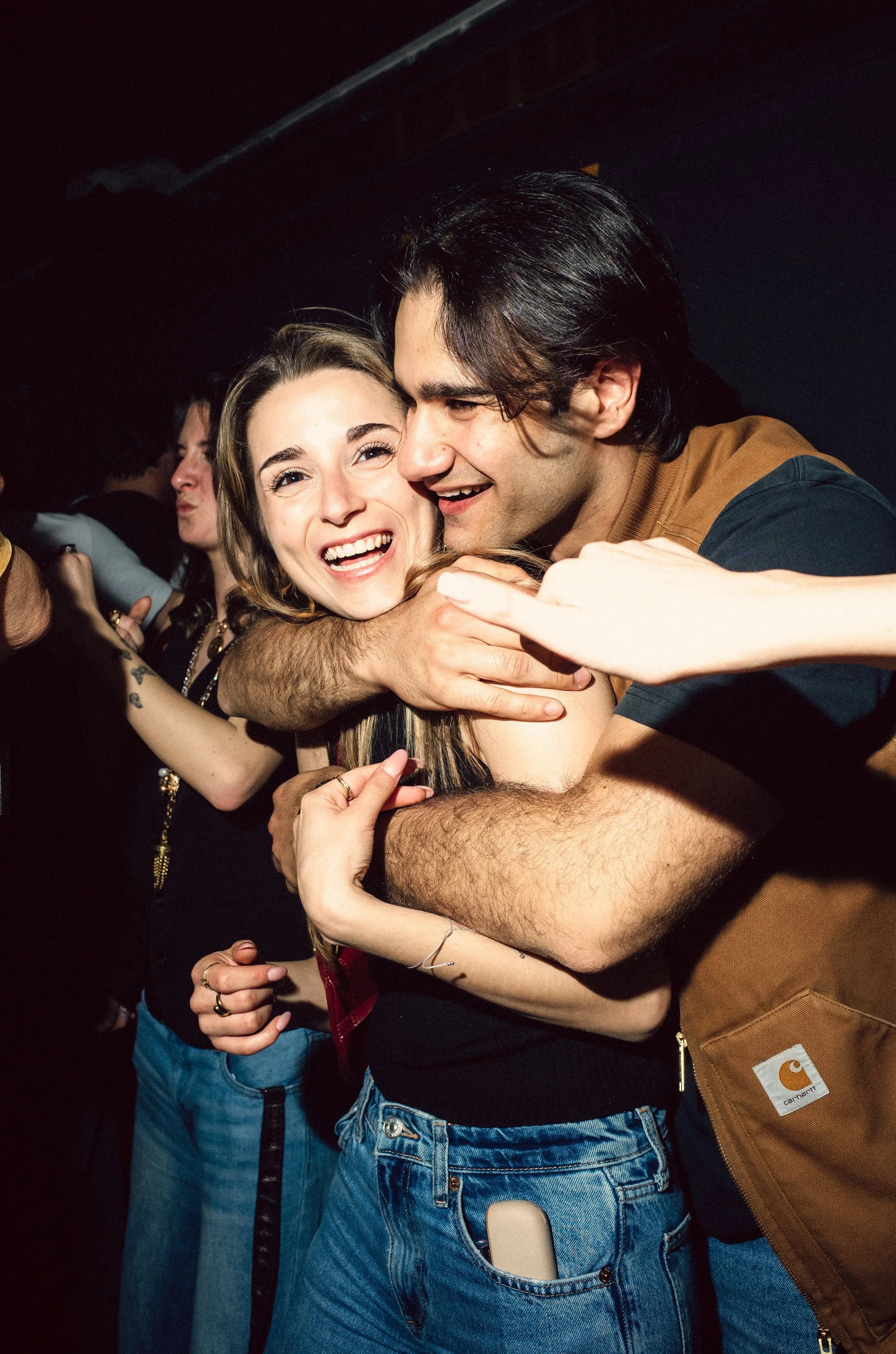 People hugging and celebrating at a party or nightclub.