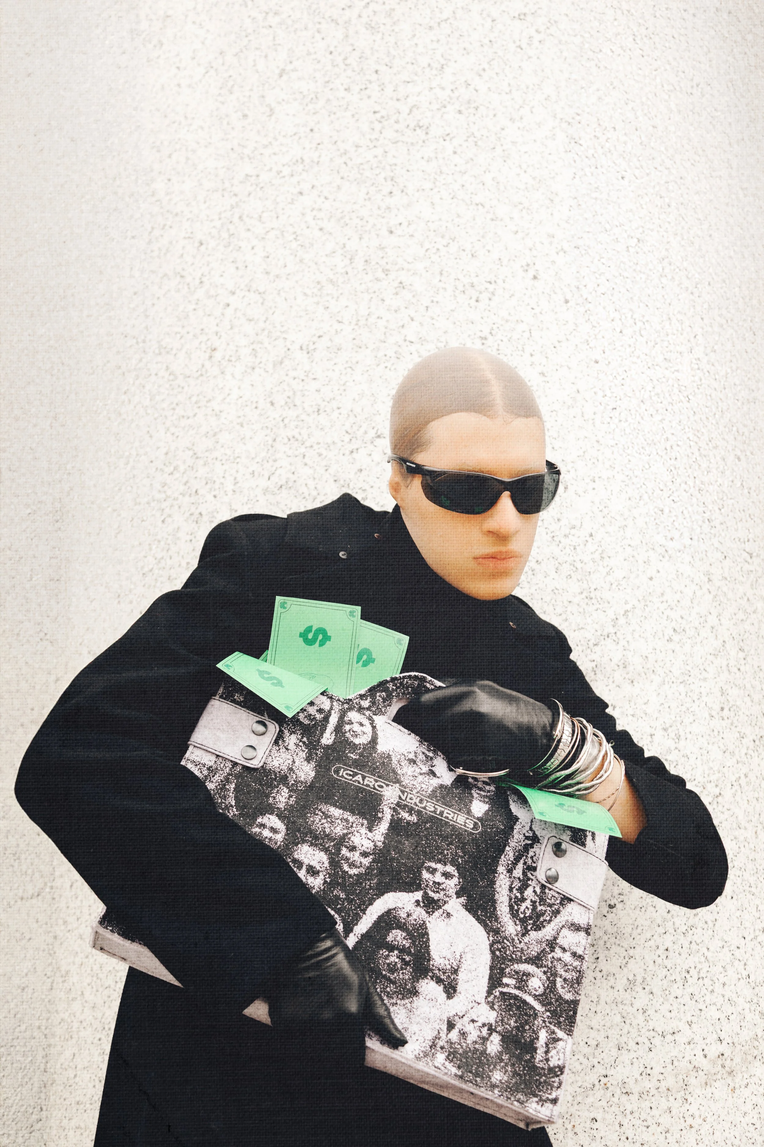 A person with sunglasses, wearing a black coat and gloves, holding a black and white poster with images of people and the text 'ICAR INDUSTRIES,' along with green paper money.