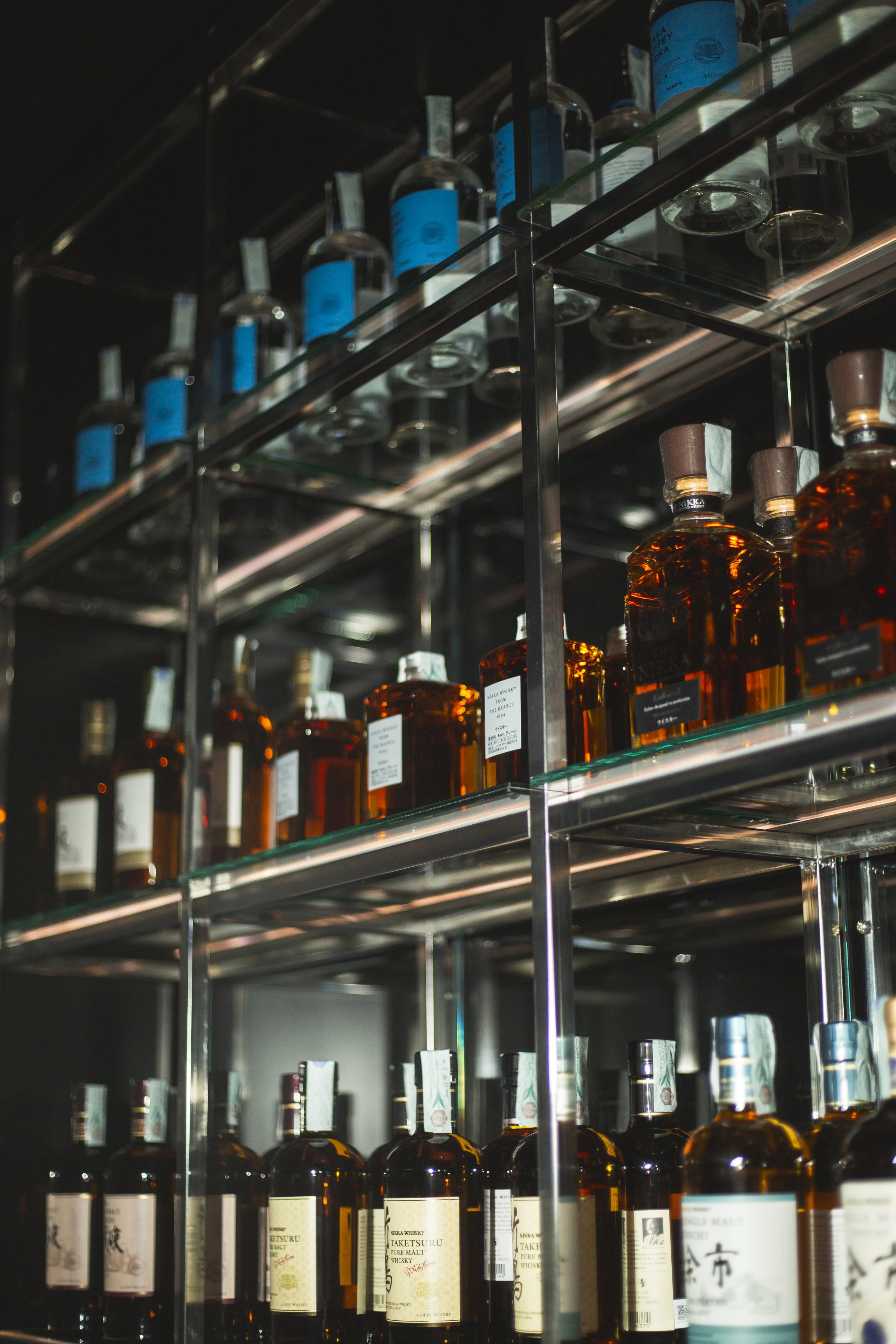Shelves stocked with bottles of whiskey and other spirits in a liquor store.