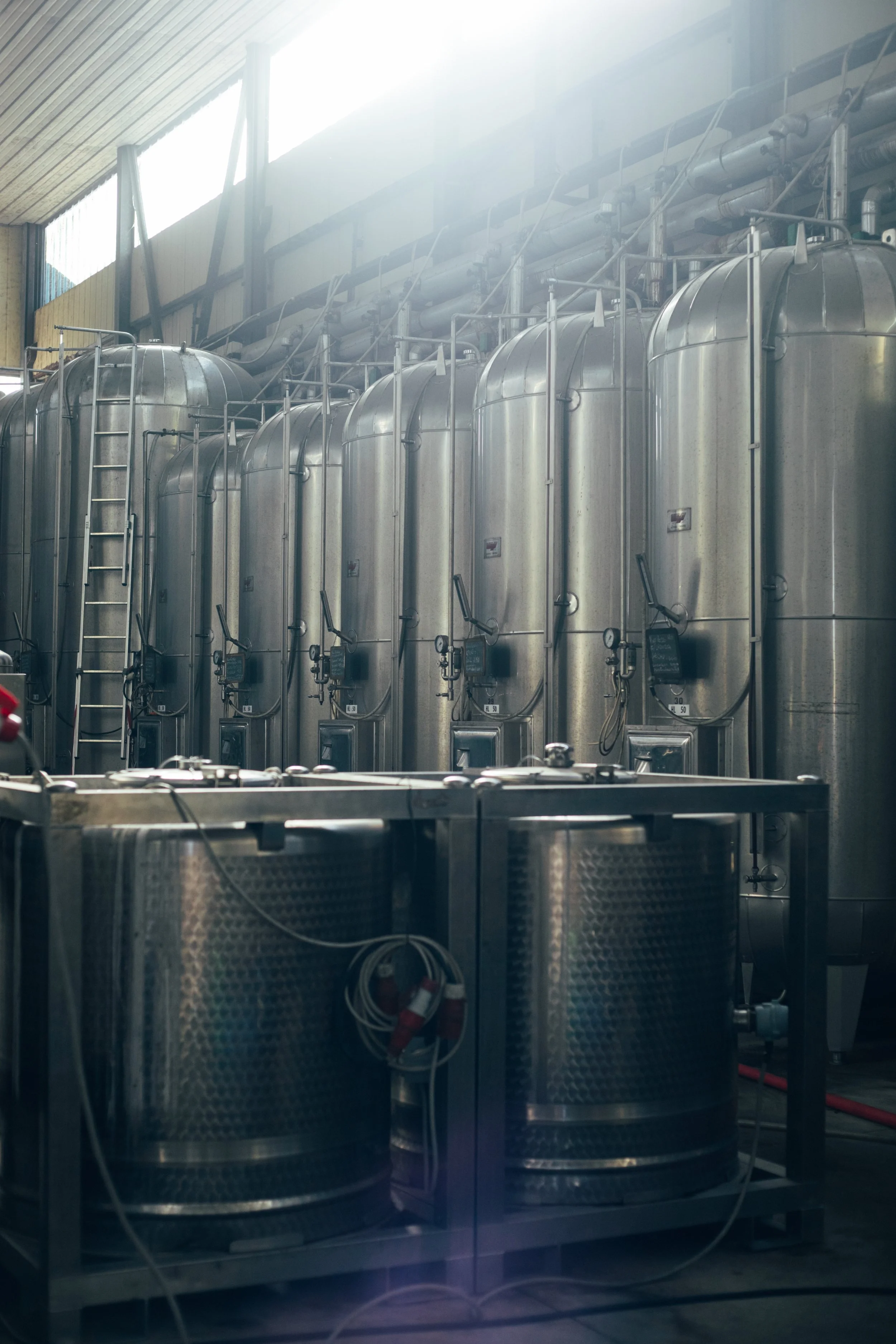 Industrial facility with stainless steel tanks and equipment, likely used for manufacturing or processing.