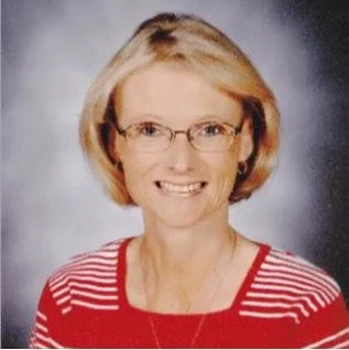 Portrait of a woman with blonde hair, wearing glasses and a red and white striped top.