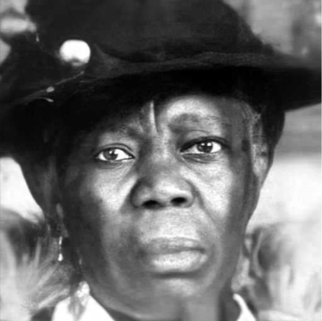 Close-up black-and-white portrait of a woman wearing a hat with a surprised expression.
