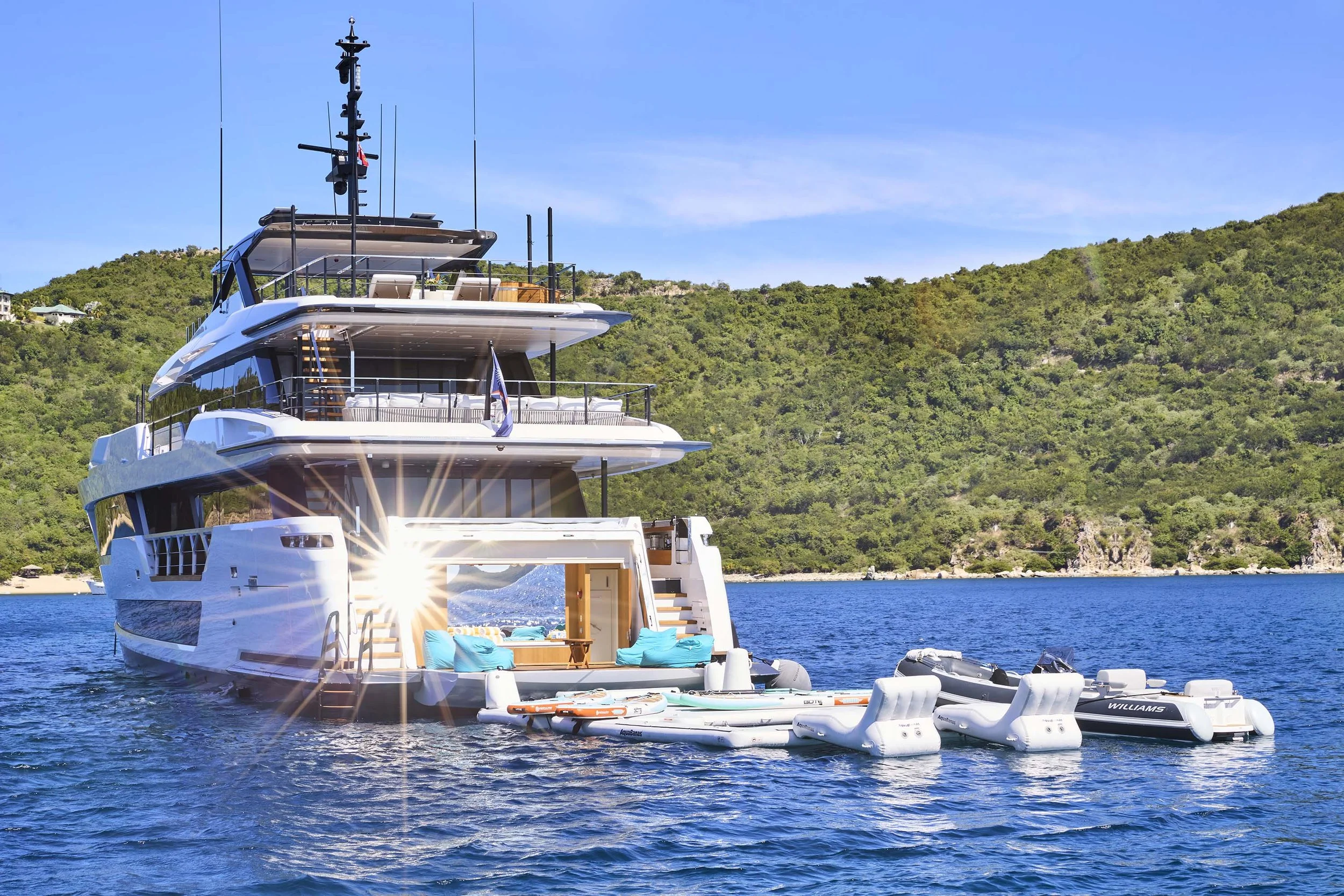 Open beach club onboard a luxury yacht with sunlight reflecting on the water