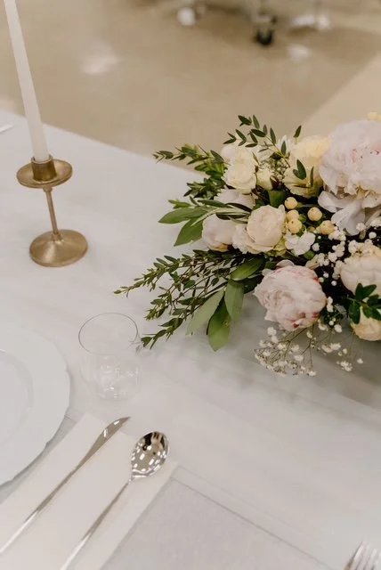 Elegant table setting with a floral centerpiece, candle, glass, and silverware