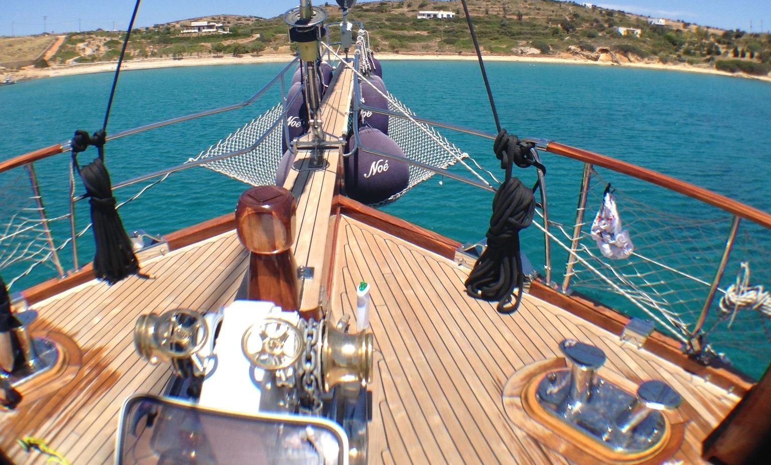Bow view from a wooden gulet over turquoise water.