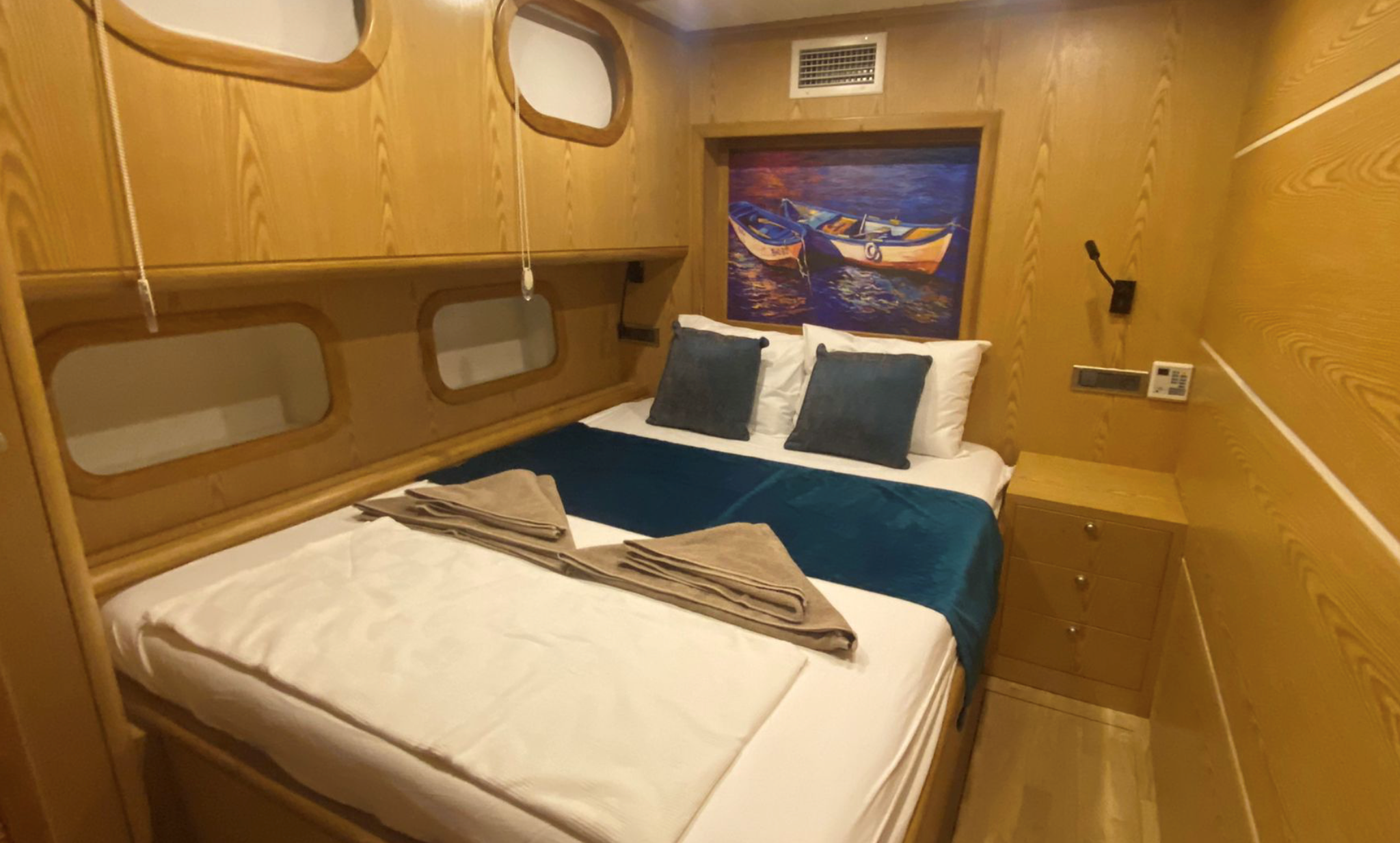 Private gulet bedroom with navy bedding and wooden interior