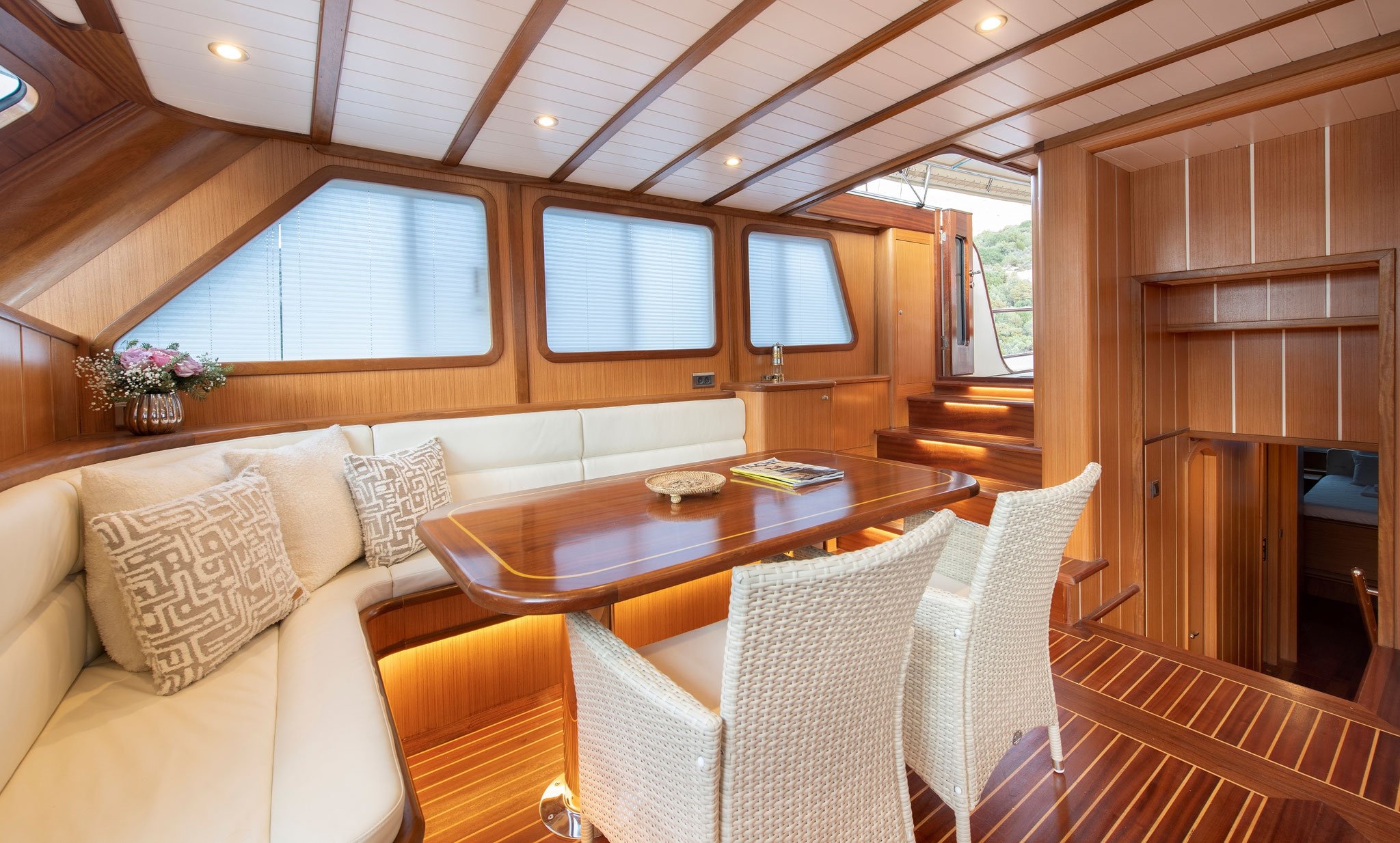 Luxury gulet interior with curved seating and dining area.