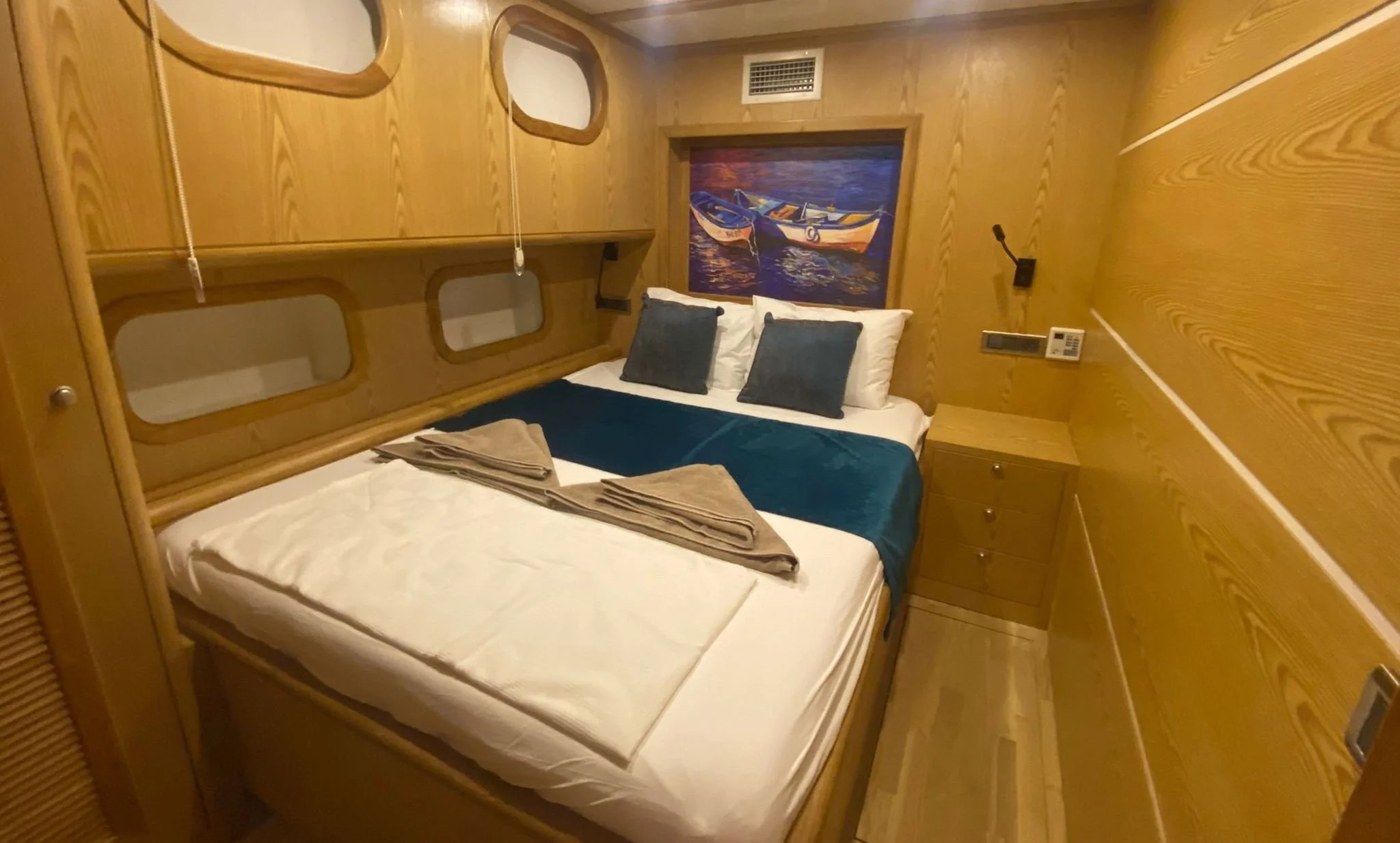 Private gulet bedroom with blue blanket and wooden walls
