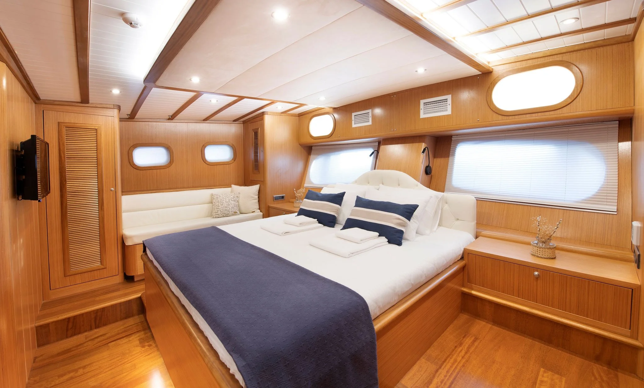 Private gulet bedroom with wooden walls and blue details.