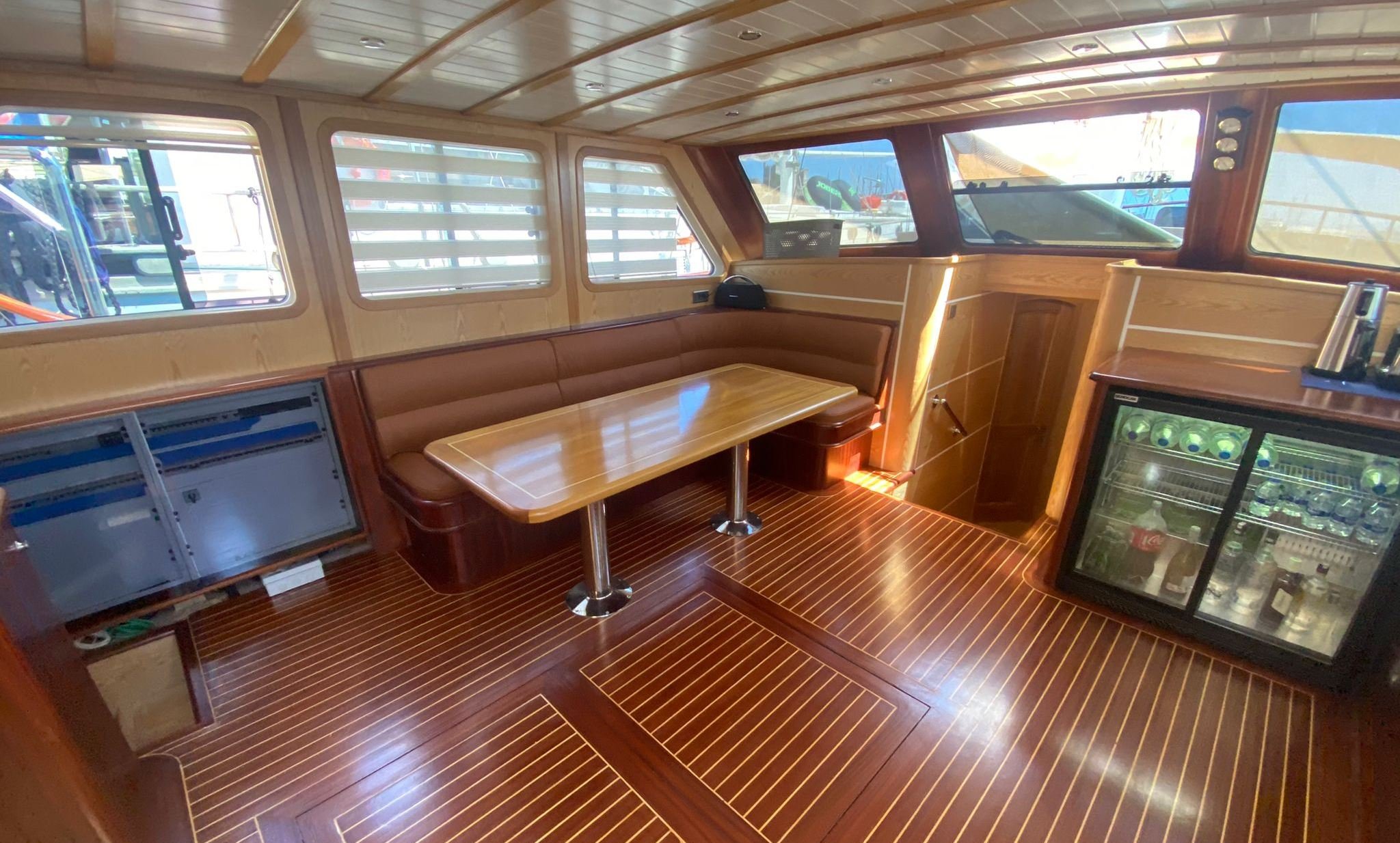 Wooden gulet interior with dining area and wine cooler