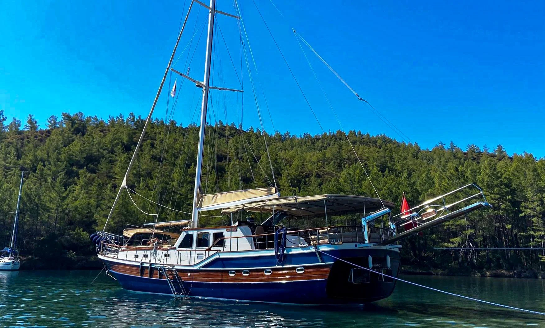 Private gulet docked beside a green hillside