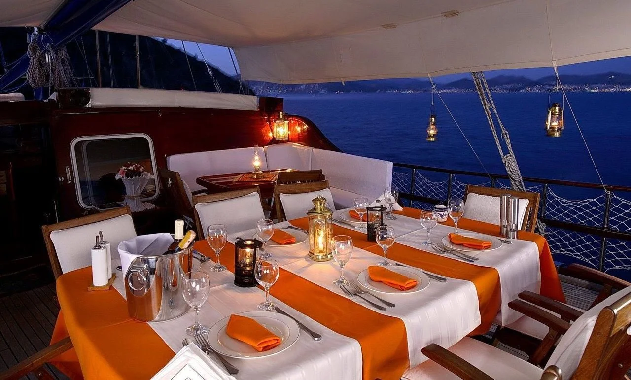Dinner table setup on a private gulet at dusk
