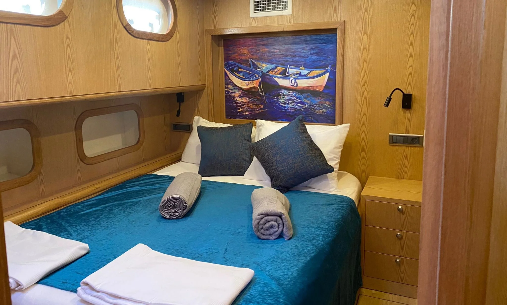 Private gulet bedroom with blue bedding and built-in cabinets