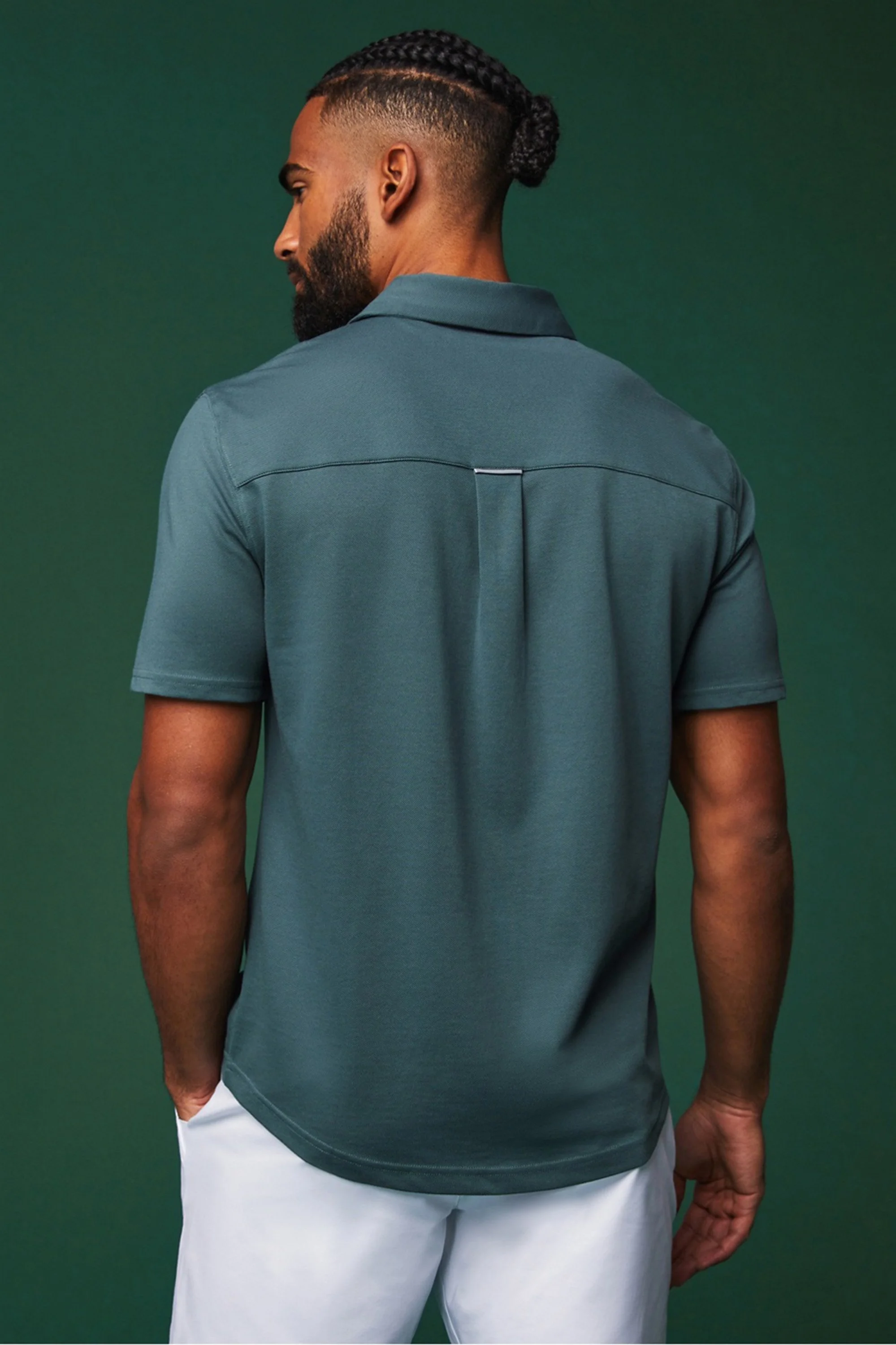 Golf performance apparel campaign photographed in studio with green backdrop.