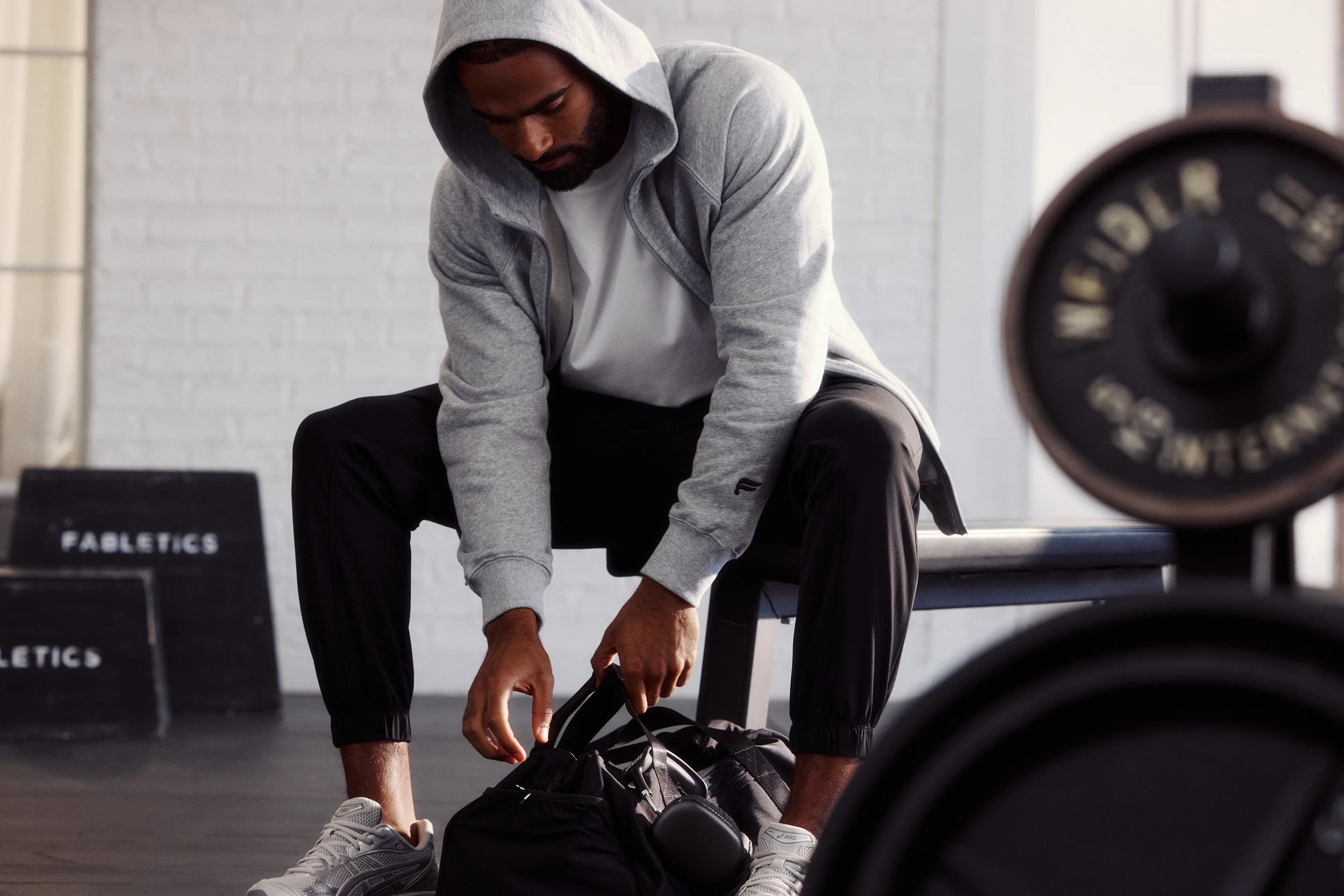 Art director on-figure e-commerce shoot, Los Angeles. A man opening a bag at the gym.