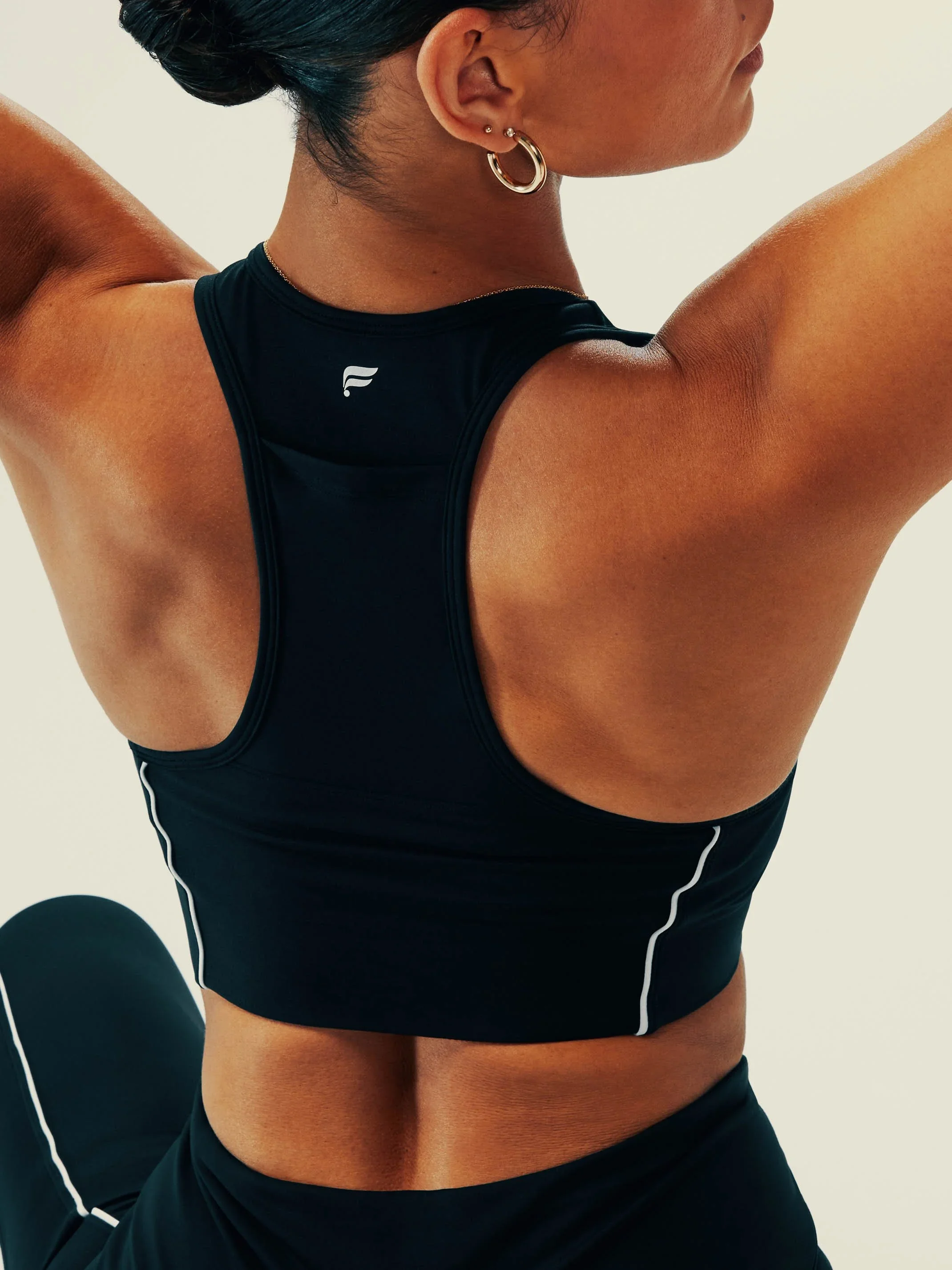 Activewear campaign art direction featuring a female athlete stretching in studio.