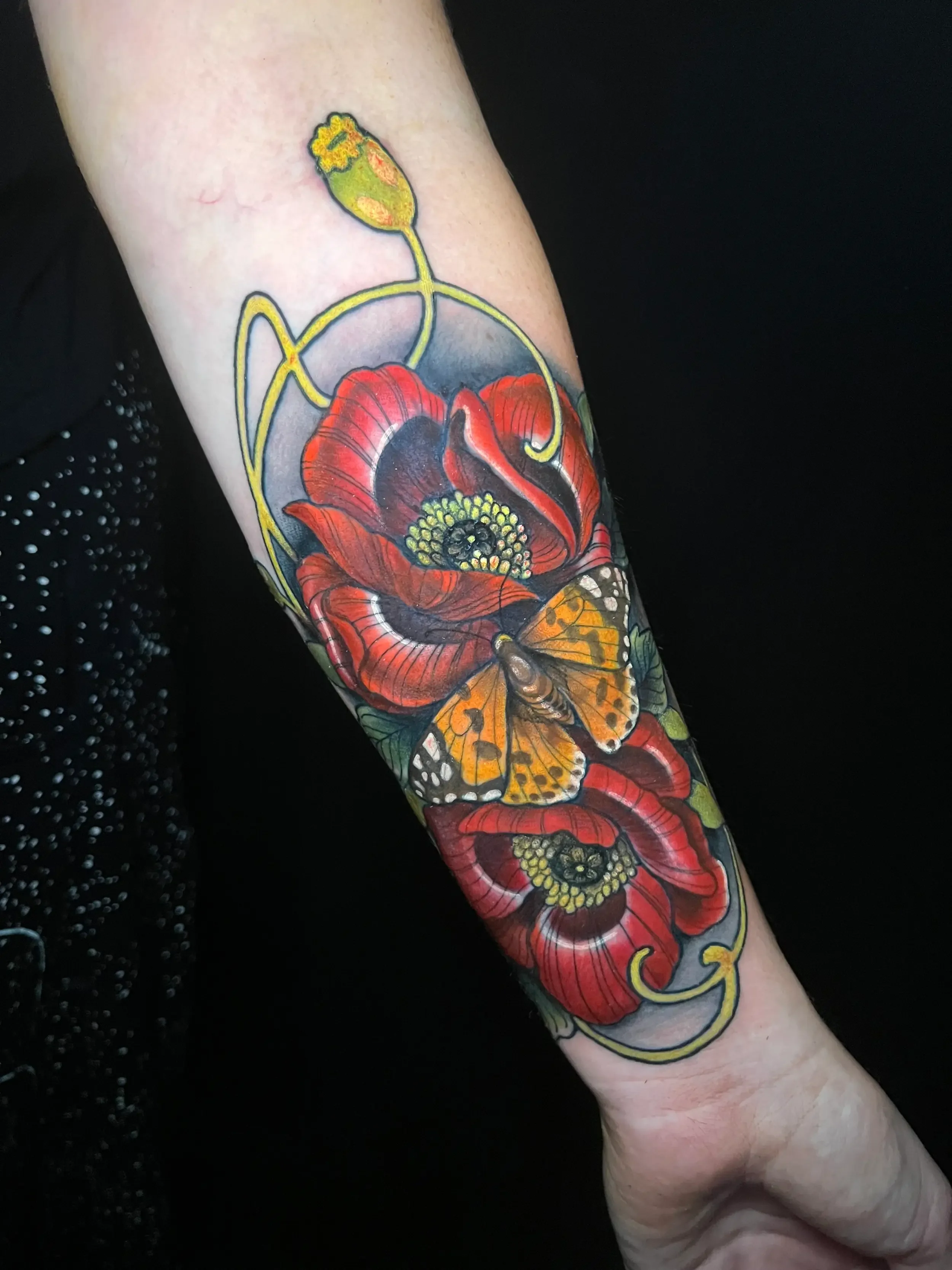 Neo-traditional forearm tattoo of red poppies and an orange butterfly. Custom Design by female tattoo artist Dana Carlson in RVA.