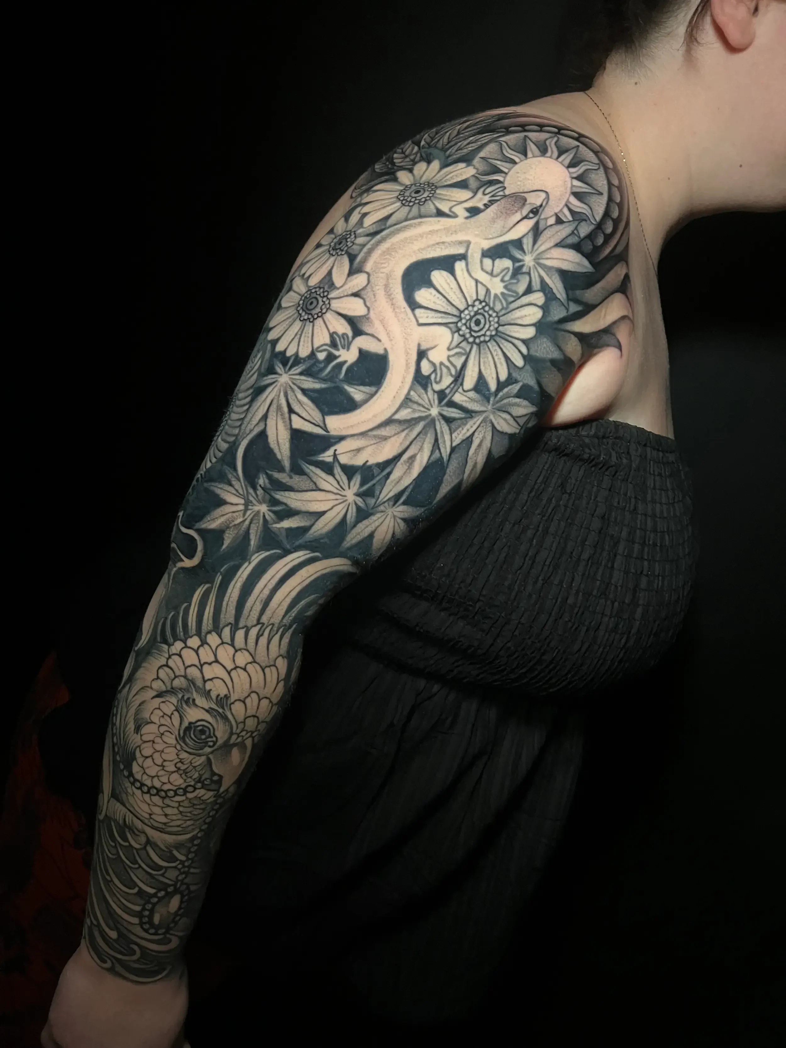 Custom neo-traditional, illustrative black and gray tattoo sleeve featuring a lizard, flowers, bird, and foliage. Done by female tattoo artist Dana Carlson in RVA.