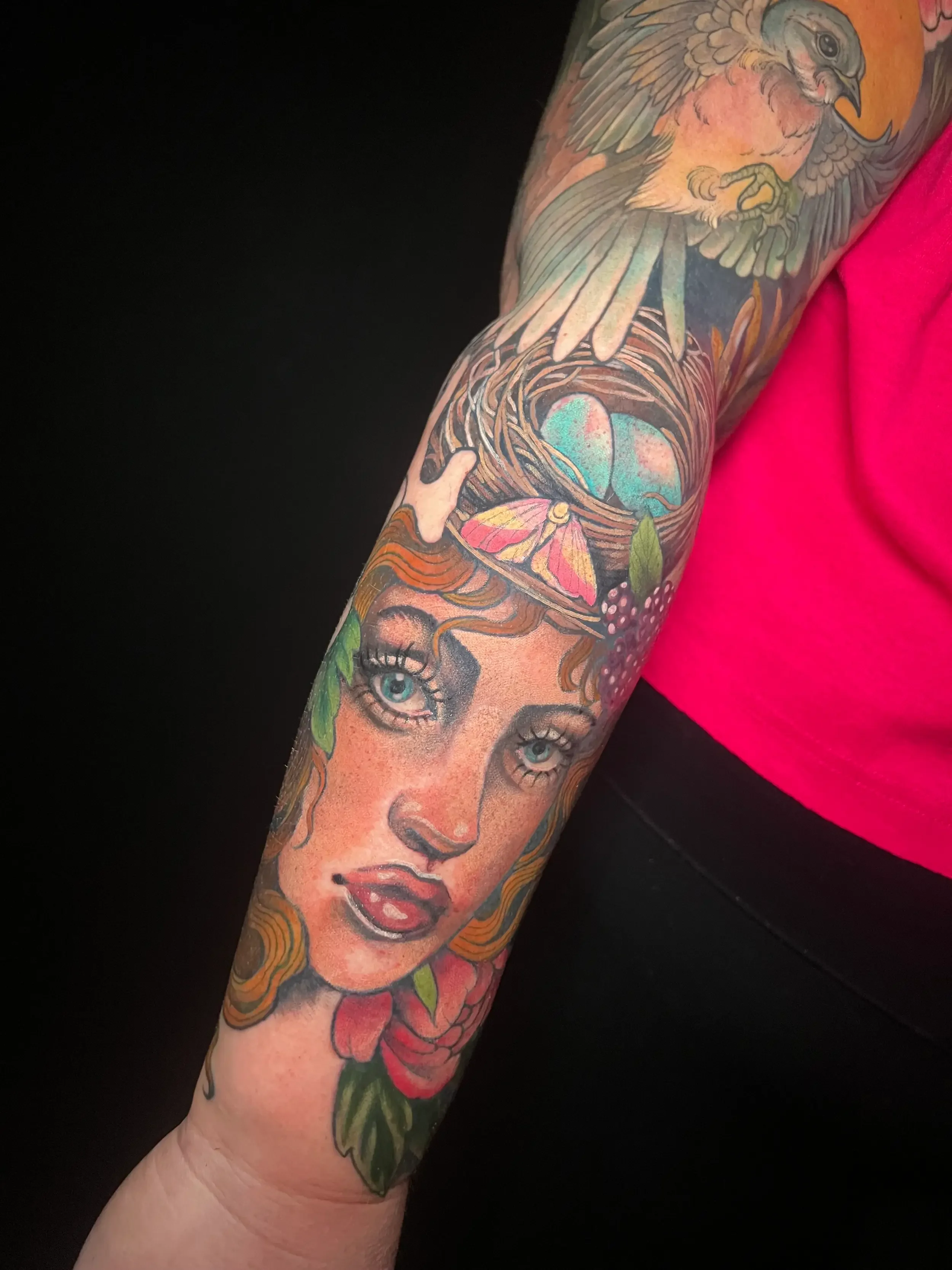 Neo-traditional color tattoo of a woman's face surrounded by colorful flowers and a bird with an eggs nest above. Done by female tattoo artist Dana Carlson in Virginia.