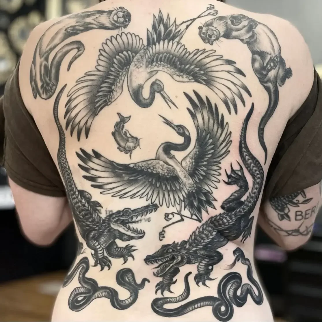 Back tattoo featuring multiple mythical and fierce animals, including dragons, snakes, a crane, and a serpent, with detailed black and gray shading. Custom design by Jess, tattoo artist in Richmond, Virginia.