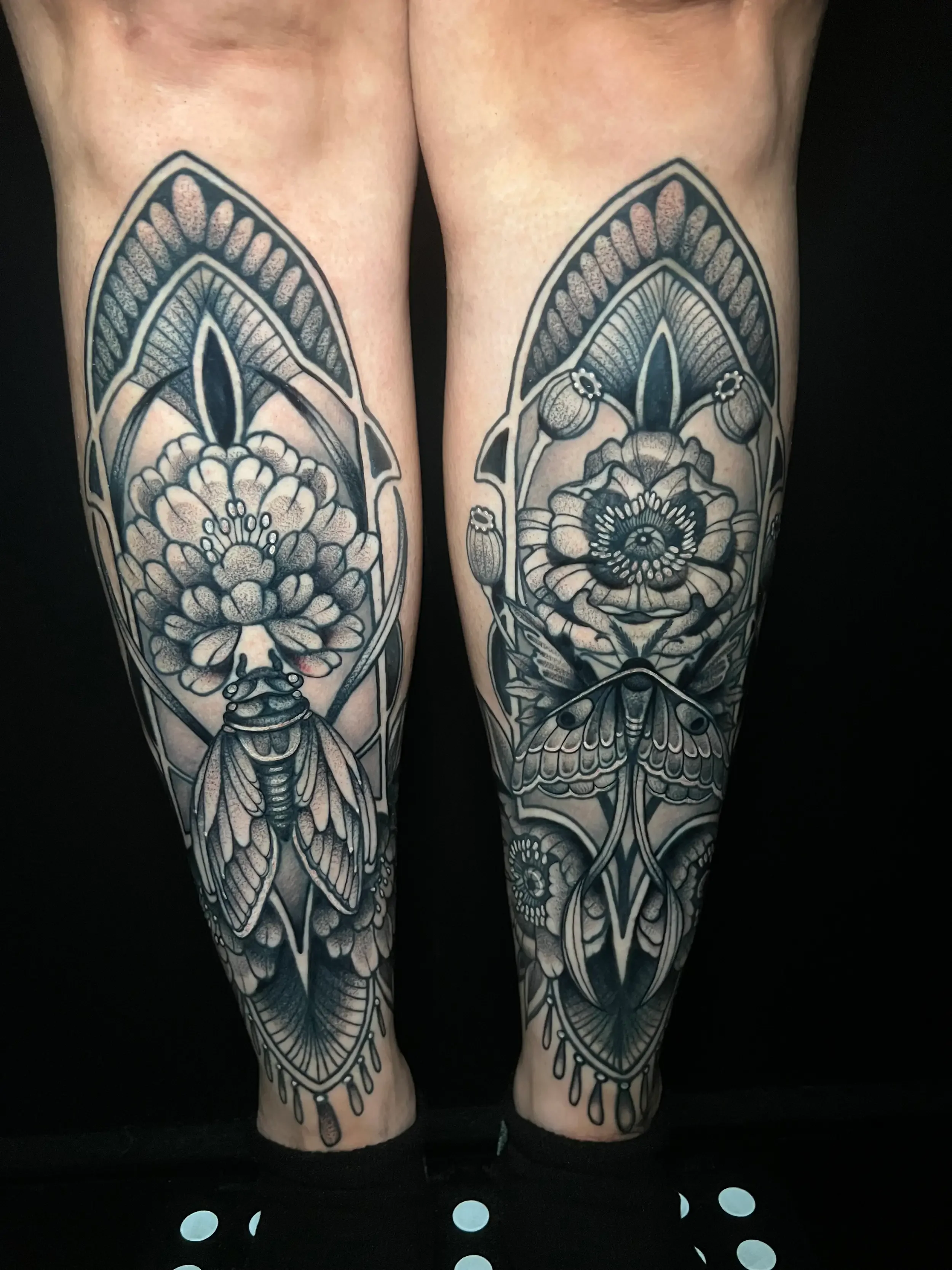 Neo-traditional black and gray floral tattoo sleeves on both legs, featuring flowers, moths, and fantasy decorative elements. Done by female tattoo artist Dana Carlson in Virginia. Done by female tattoo artist Dana Carlson in Virginia.