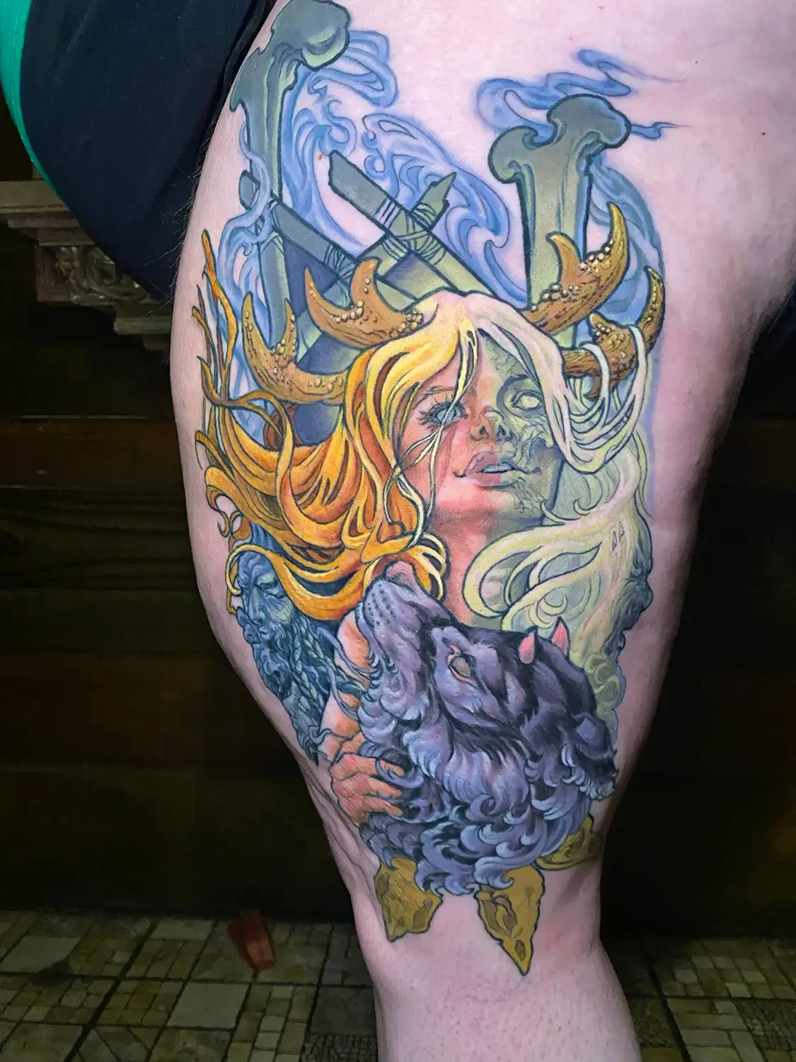 Colorful tattoo of Hel and her hellhound surrounded by swords and stormy clouds. Custom Design by RVA tattoo artist Fronkie.