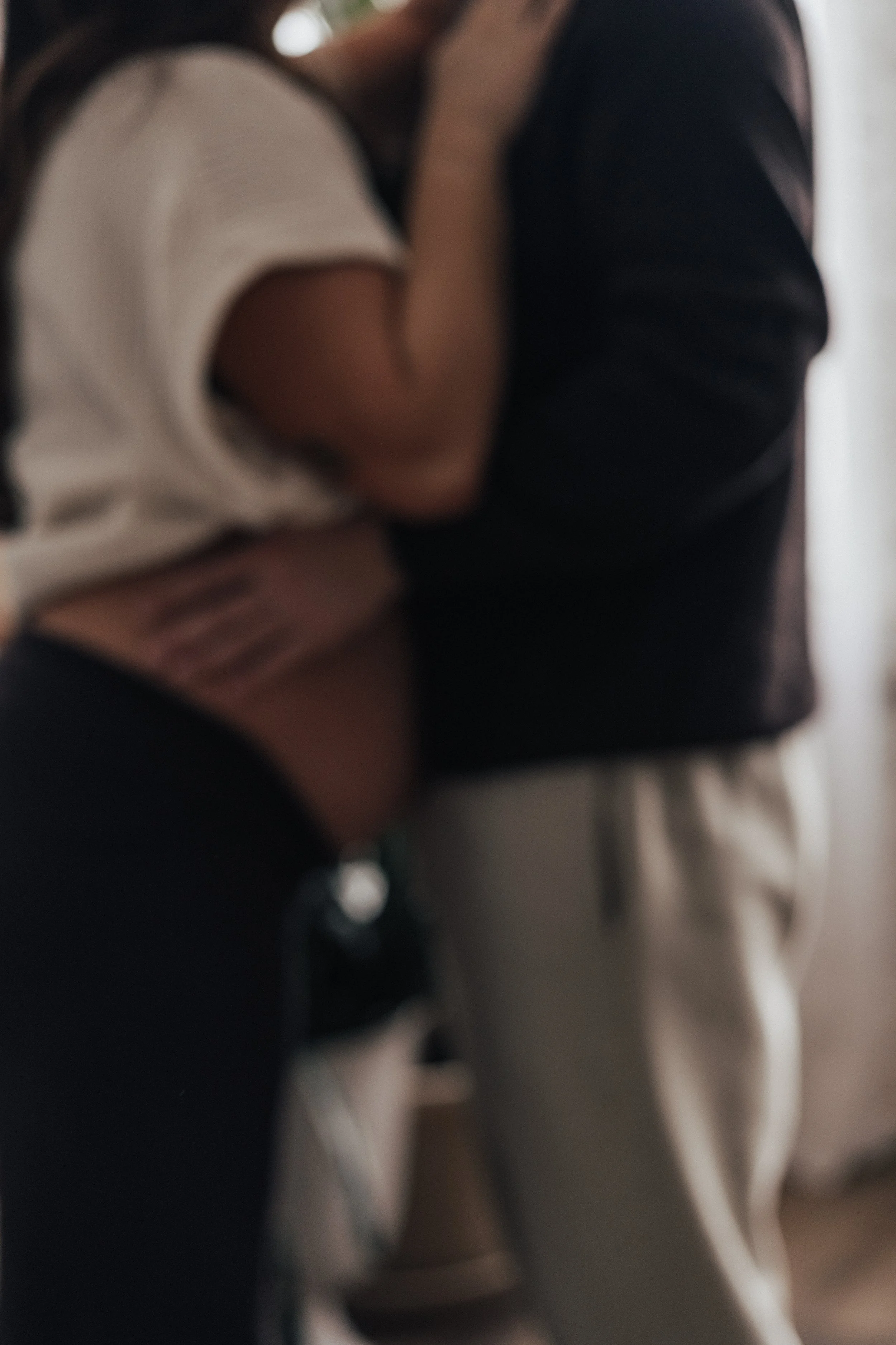 A pregnant couple with a man holding his wife's belly in a studio in Cleveland ohio