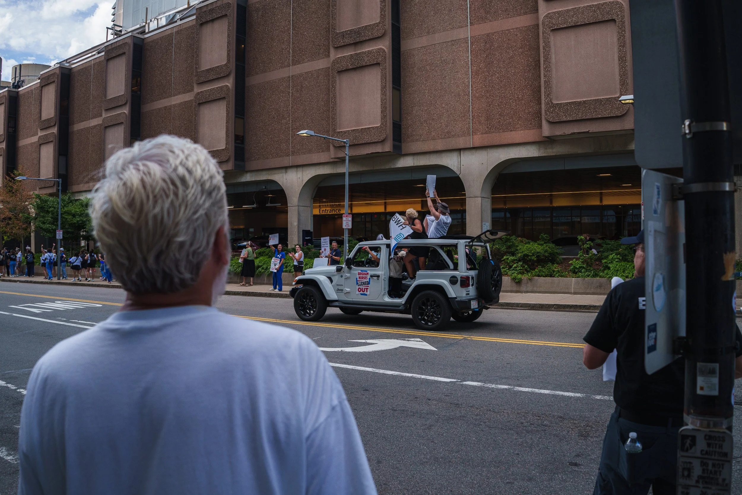 A vehicle full of nurses passes on-lookers and fellow protesters in the July, 9 2026 Mass General Bingham Nurse protest. 

(Photo by Steve Wolfinger/Lightleak Studio)