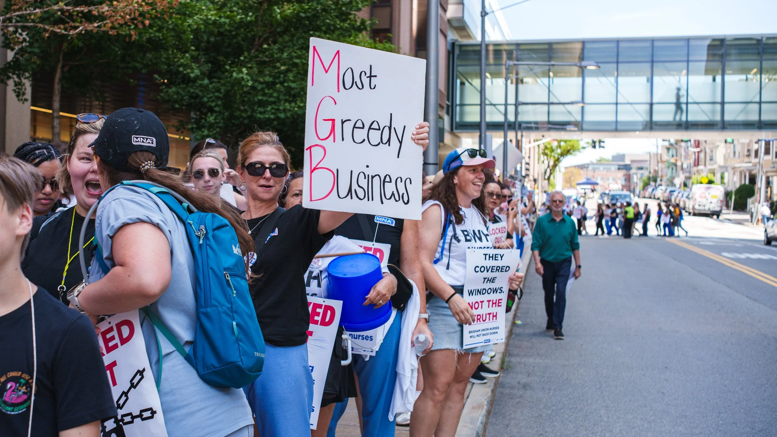 Participants in the July, 9 2026 Mass General Bingham Nurses Protest take to the streets holding signs to bring awareness to corporate greed at the hospital.

(Photo by Steve Wolfinger/Lightleak Studio)