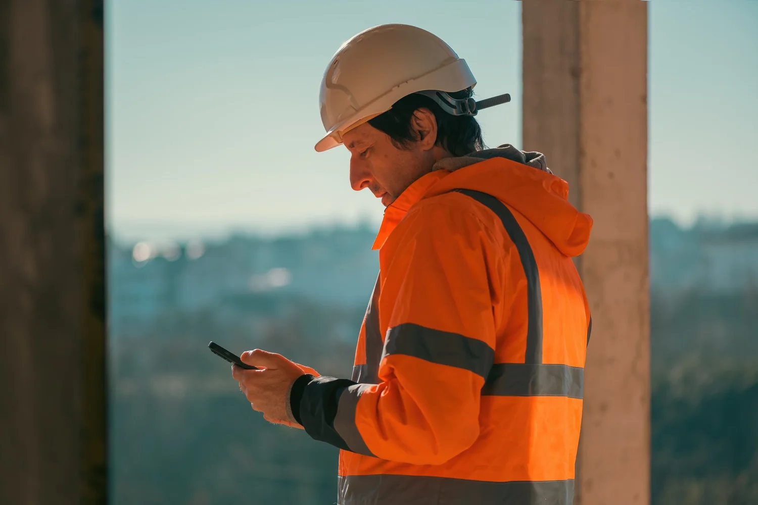 Builder on site checking a phone