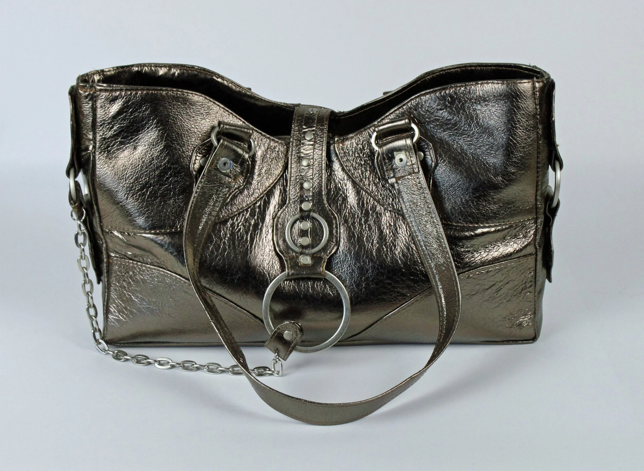 Shiny metallic silver handbag with chain and strap details on a light background.