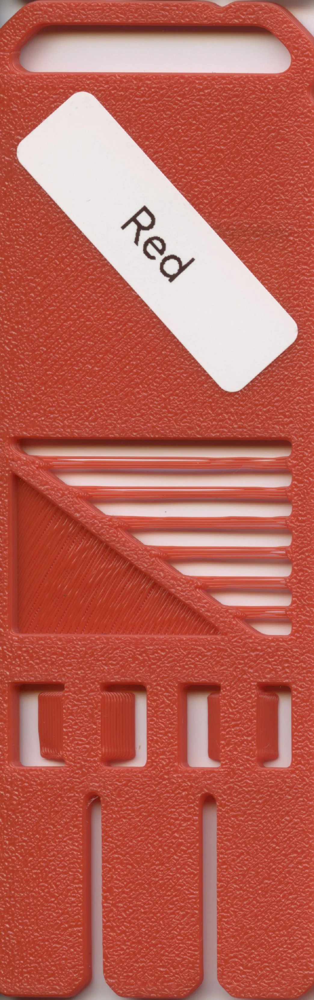 A red plastic utility knife with a white label that has the word "Red" on it. The handle has textured surface and a sliding blade mechanism.