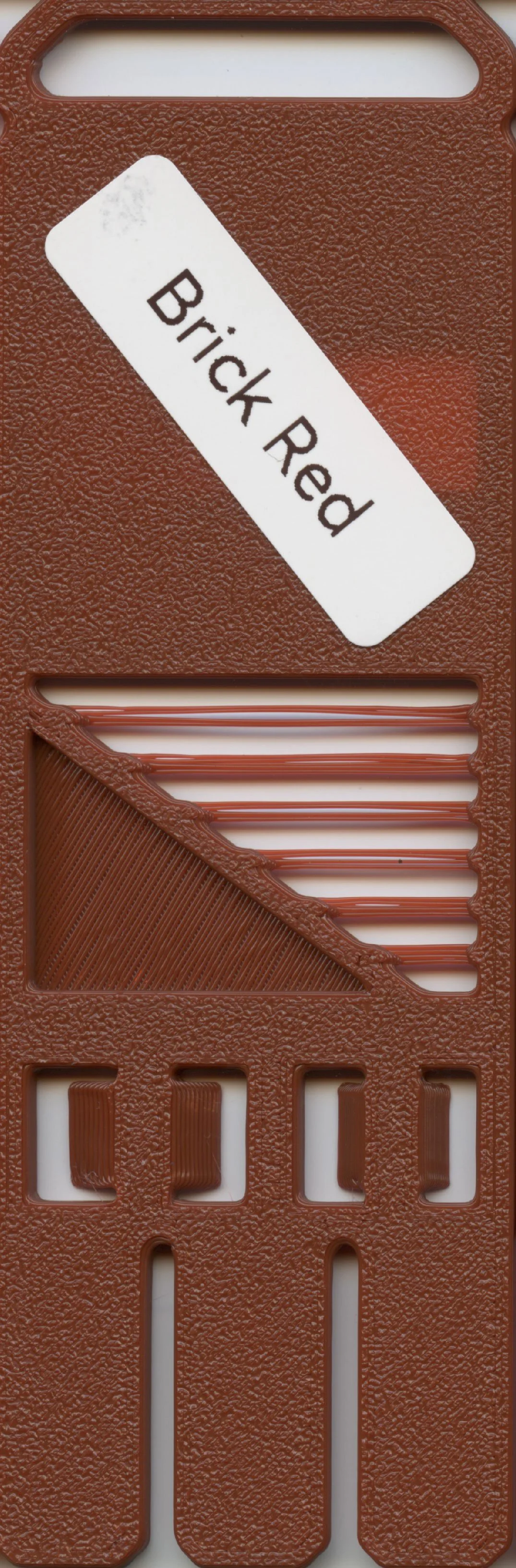 Close-up of a red plastic comb with a white label that reads "Brick Red".