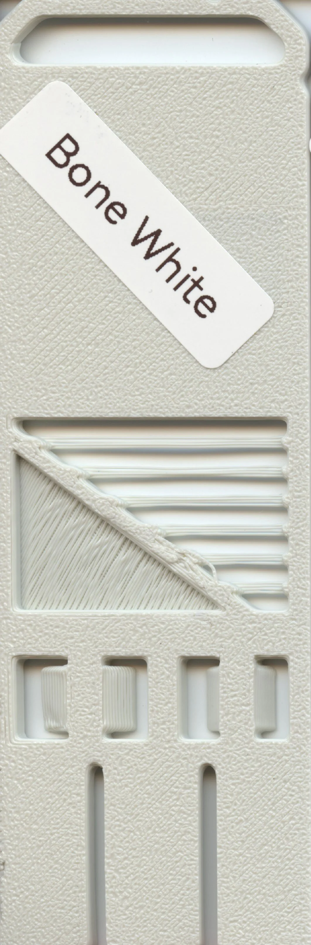 A collection of white plastic pieces, including dental impression trays, with a label that reads 'Bone White'.