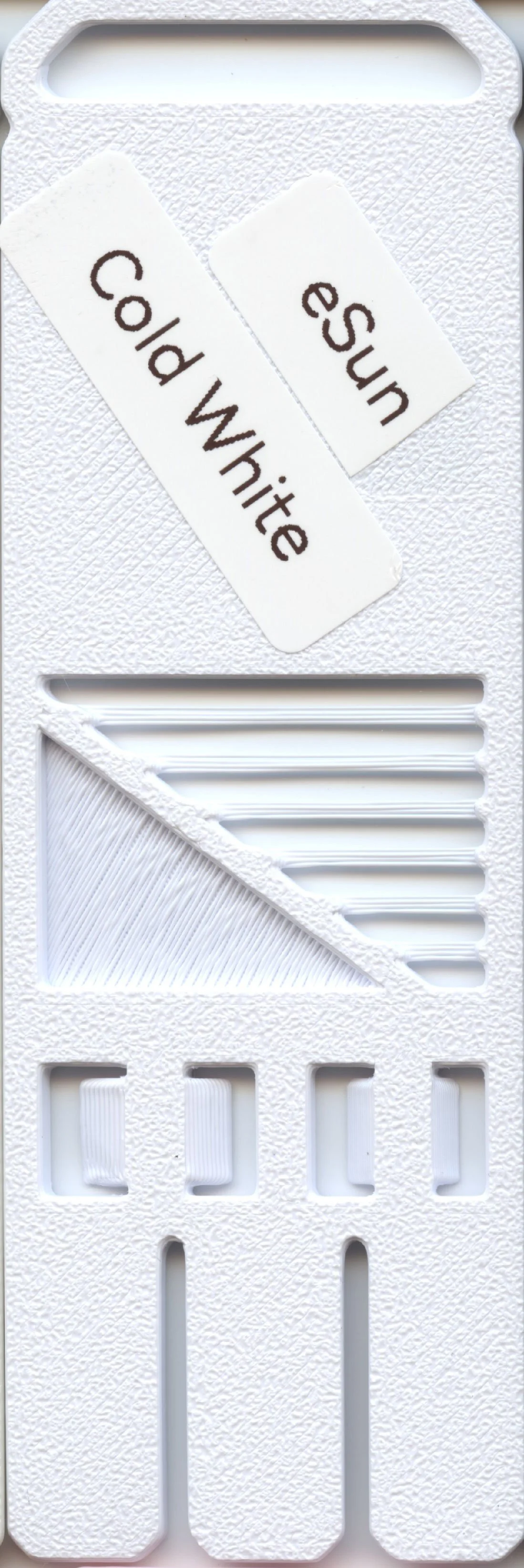 A white textured box with two paper labels reading 'sun' and 'cold white' placed on it.