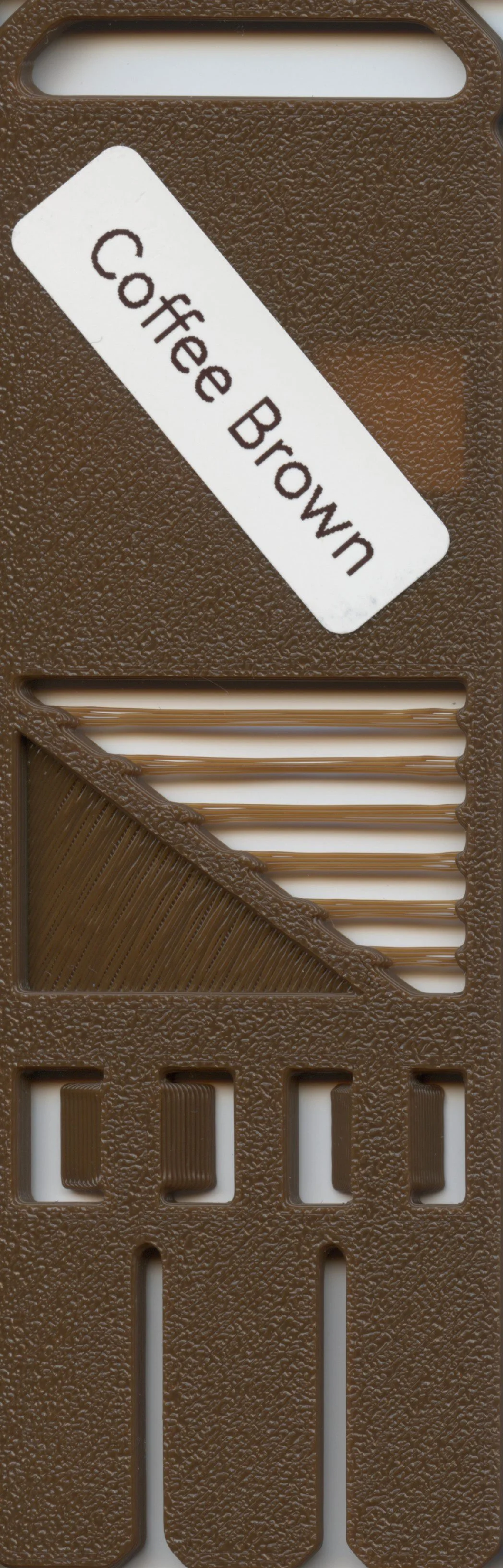 A brown coffee flavor sample with a white label reading 'Coffee Brown' and a textured plastic or foam background.