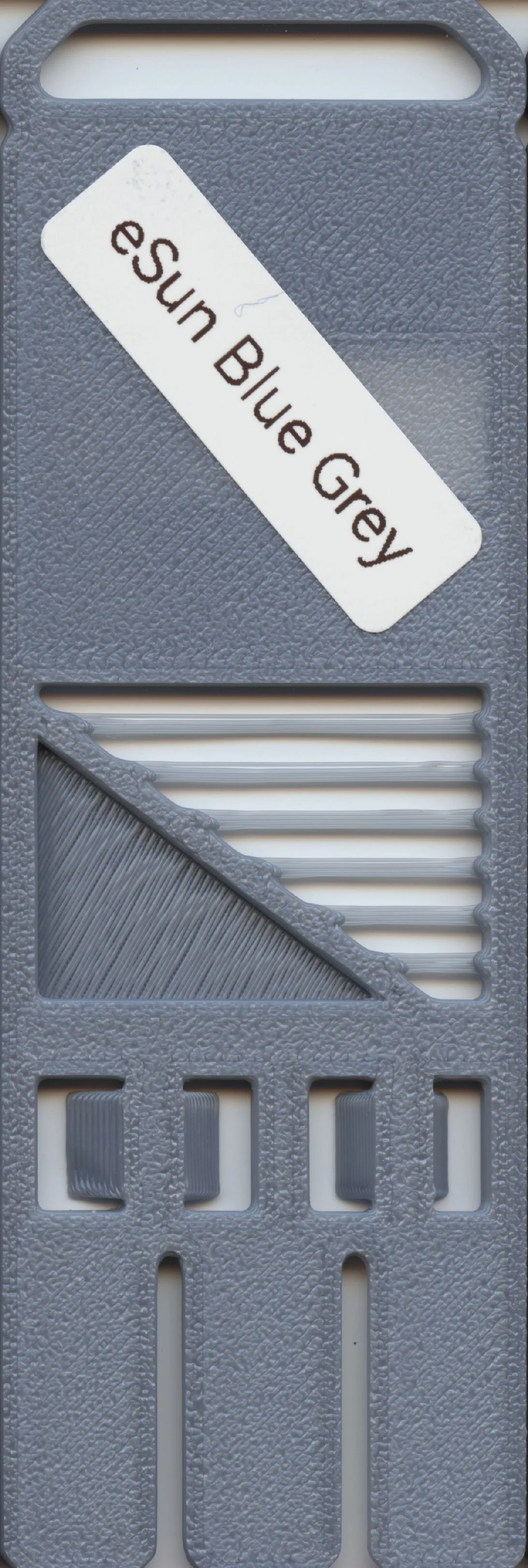 Close-up of a gray plastic blender blade attachment with a white label that reads 'eSun Blue Grey'.