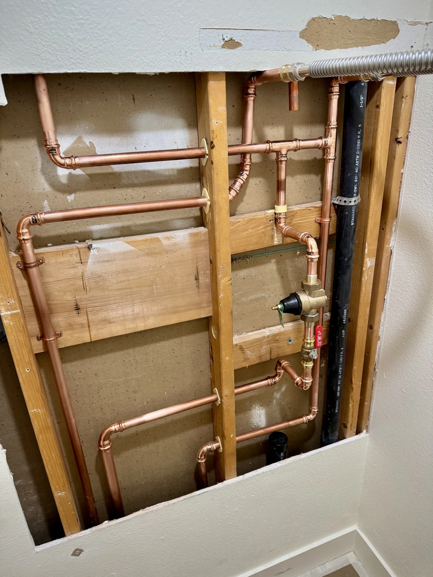 Copper supply piping, isolation valves and fittings installed within an open interior wall on an Artisan Plumbing project