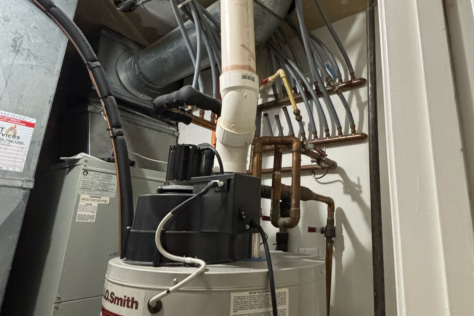 A mechanical closet showing an A.O. Smith ProMax power-vented water heater connected to a hydro-air heating air handler and a home water distribution system.