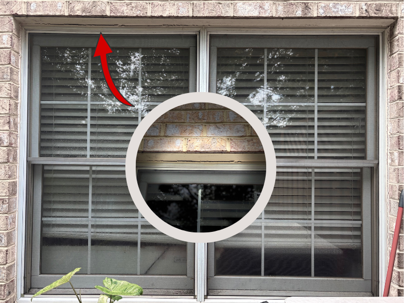 Exterior brick wall with a double window, highlighted to show a gap in the sealant along the upper window frame.