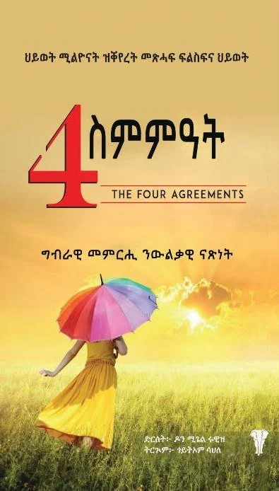 Book cover titled "The Four Agreements" in English and another language, featuring a person in a yellow dress holding a multicolored umbrella walking in a field with a sunset in the background.