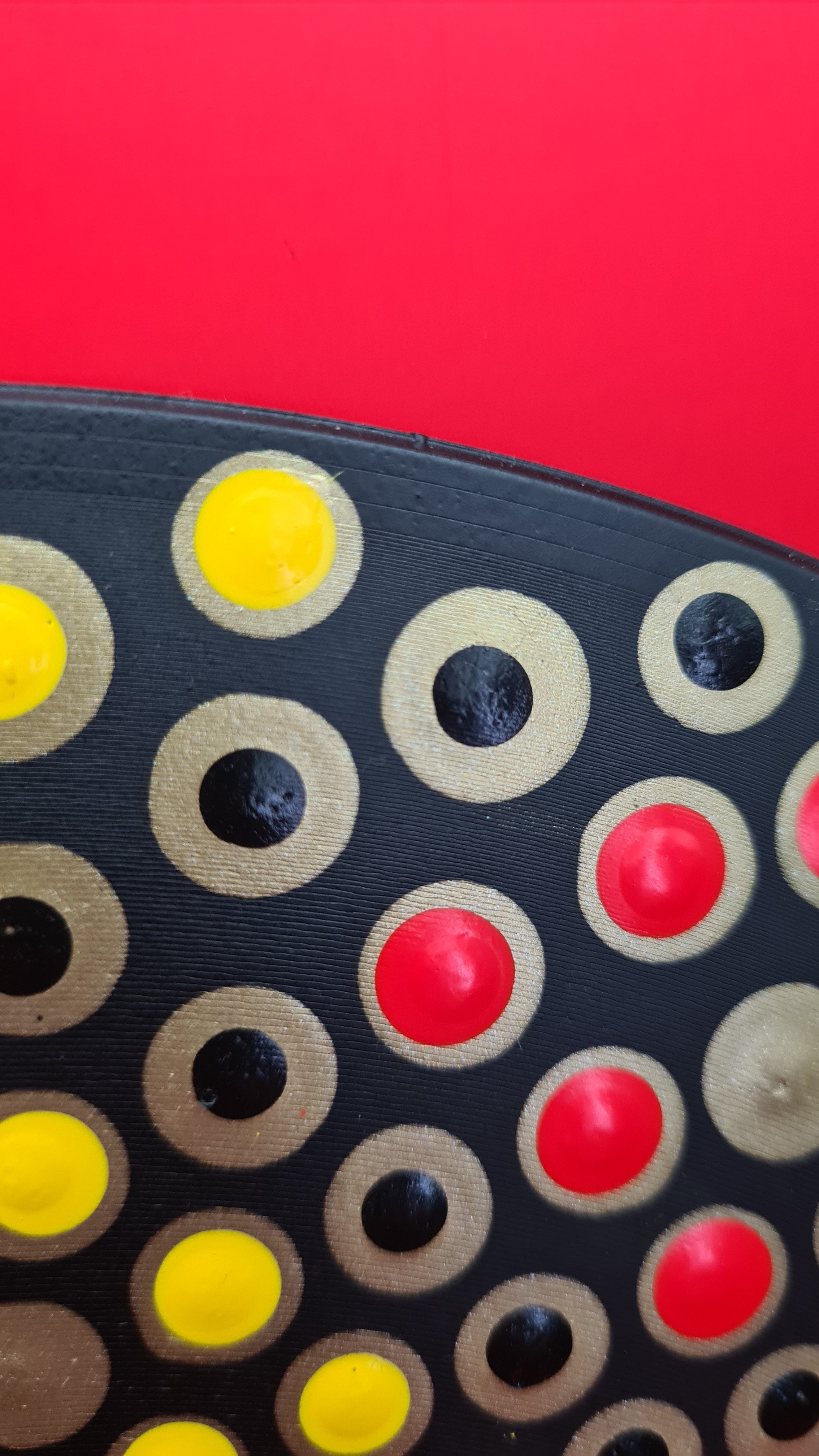 Close-up of a black and beige-colored Connect 4 game grid with yellow and red discs placed in the slots.