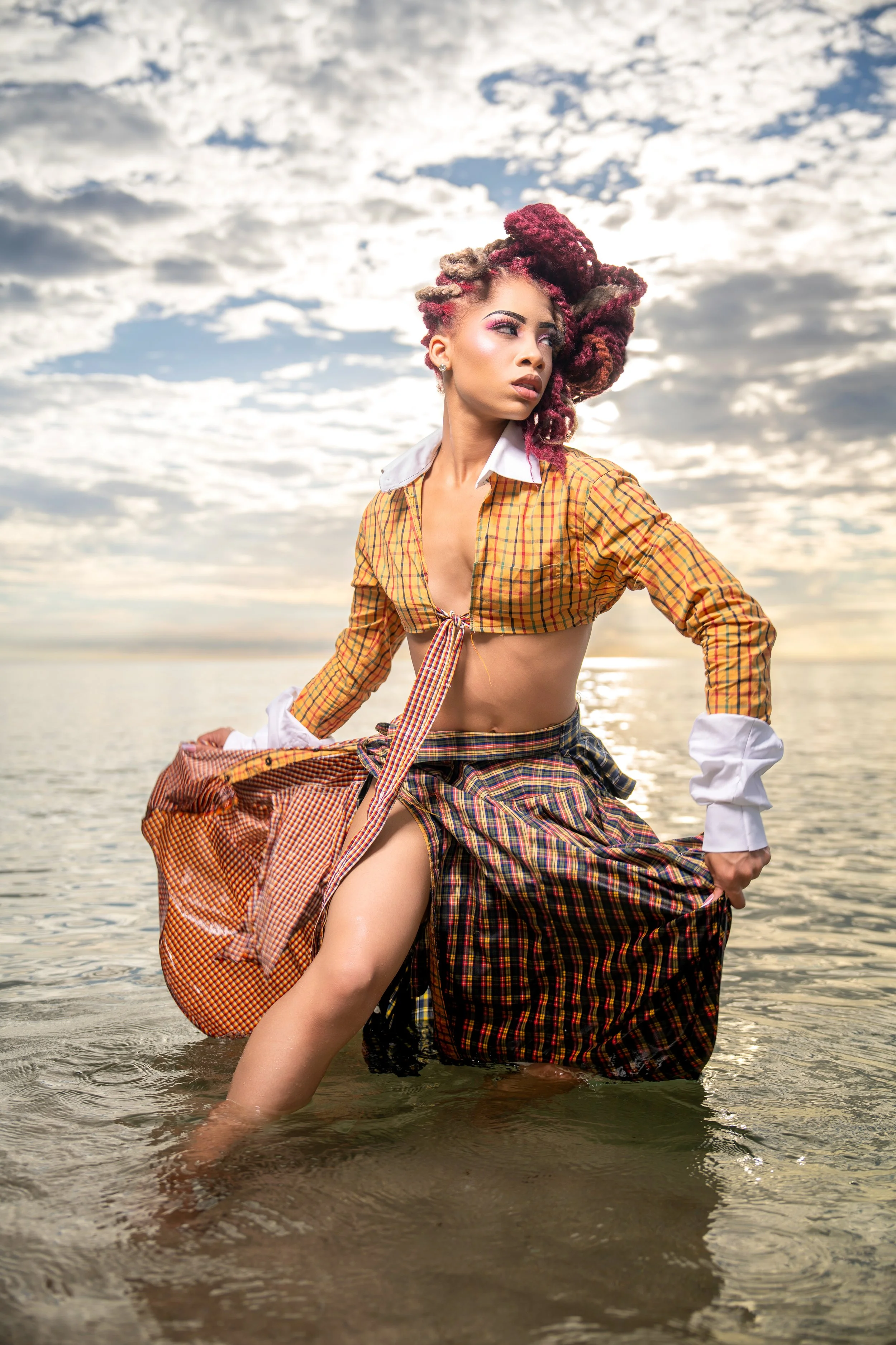 Editorial fashion portrait by Ran With A Cam featuring a woman in a mustard-colored dress seated outdoors with elegant styling and confident pose.
