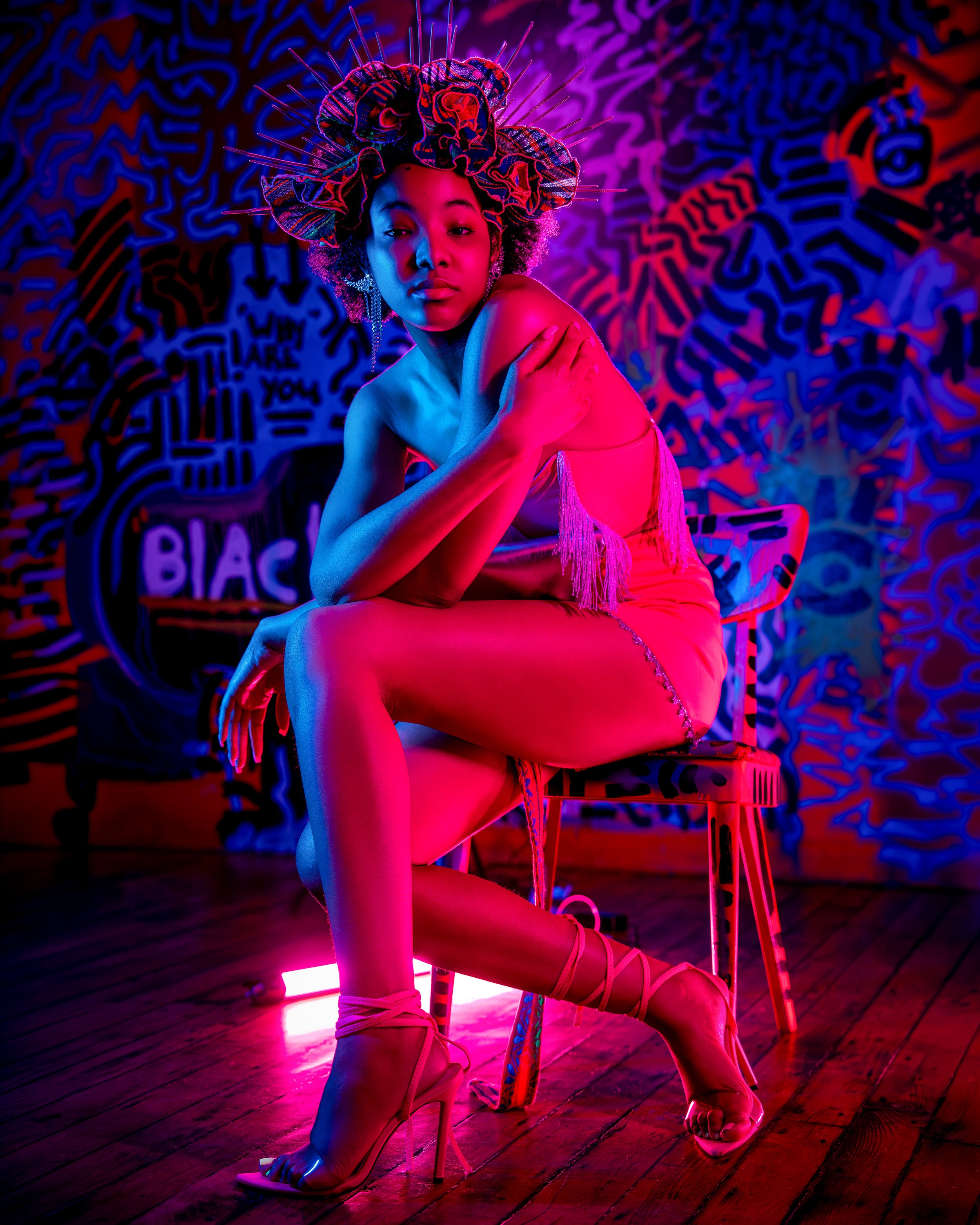 Editorial portrait featuring dramatic neon lighting and modern high-fashion styling.