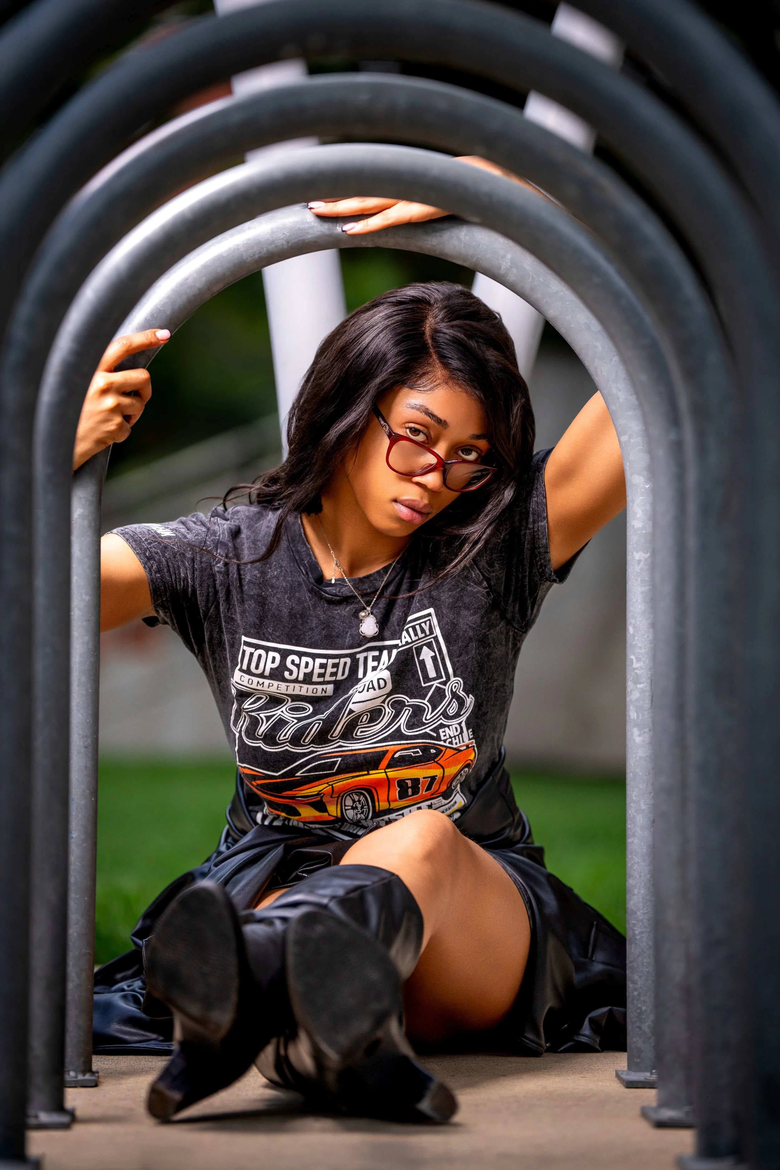 Creative editorial fashion portrait featuring a seated model framed through repeating architectural curves, using symmetry, depth, and perspective to create a bold composition.