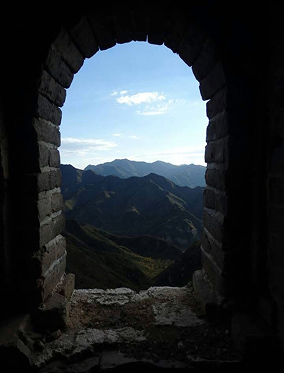 View of mountains through a stone arched window