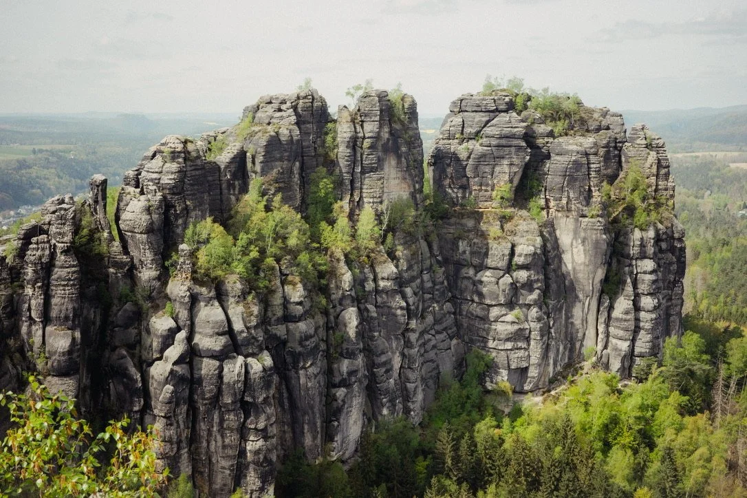 Rock formations surrounded by greenery in a natural landscape.