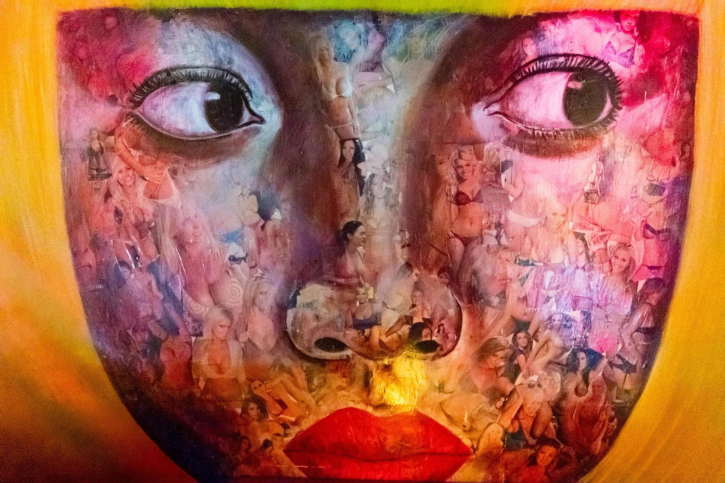 Close-up of a mixed-media artwork featuring a pair of human eyes with long lashes, surrounded by collage images of women in various poses and outfits, with vibrant colors and textured brushstrokes.