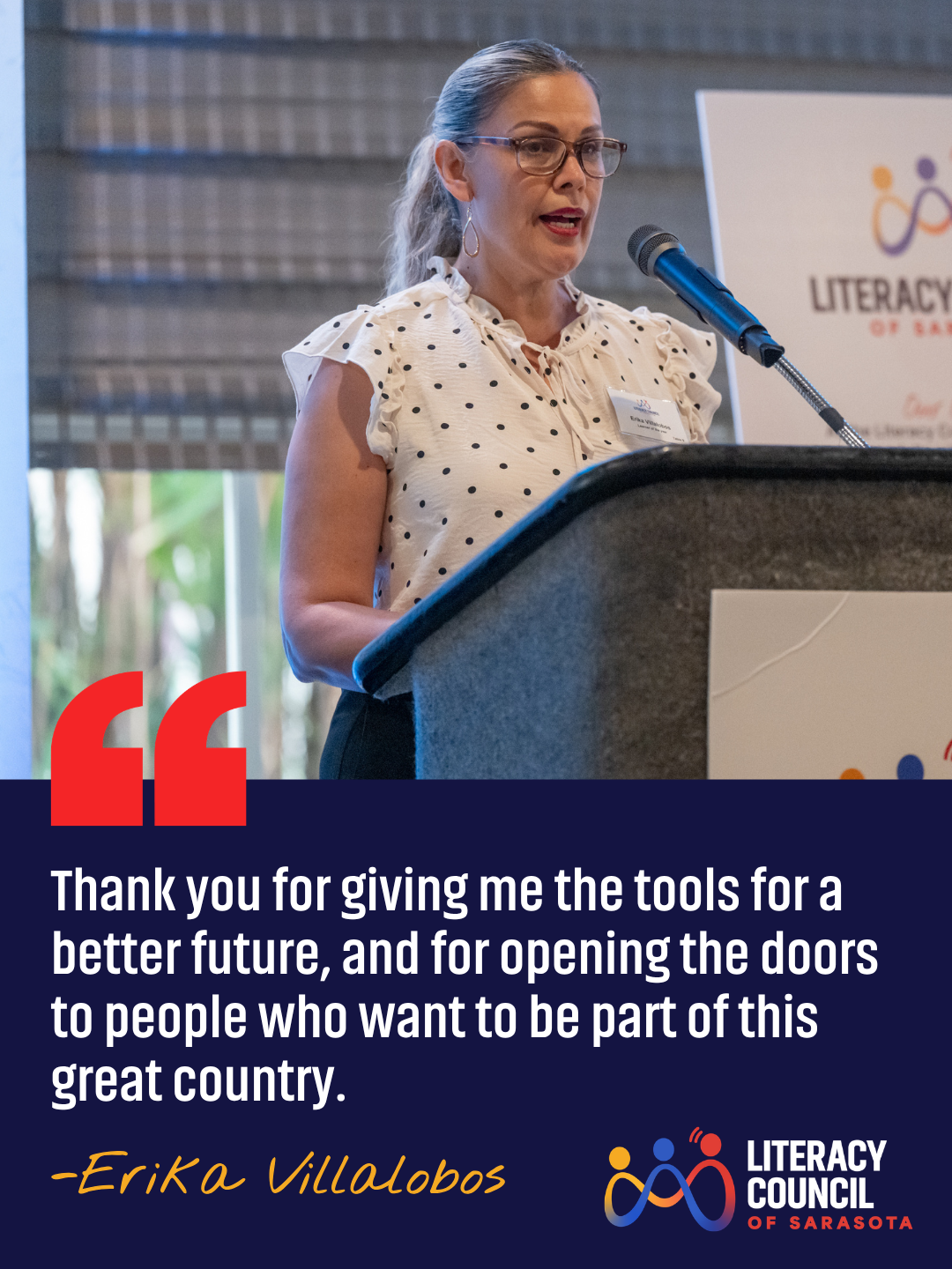 Woman speaking at a podium during the Literacy Council of Sarasota event, with a banner in the background displaying the organization's logo.