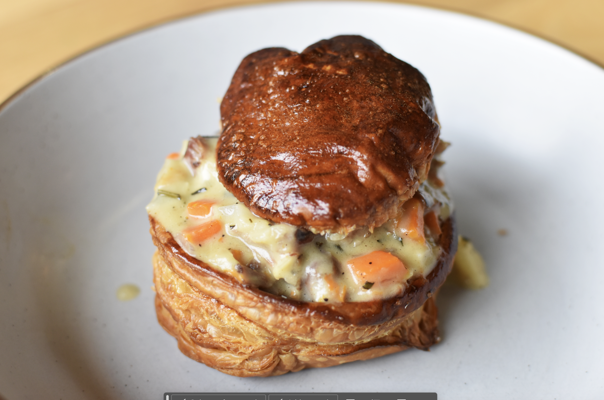 A plated serving of a savory meatloaf with mashed potato topping, topped with a brown sauce or gravy, served on a white plate.